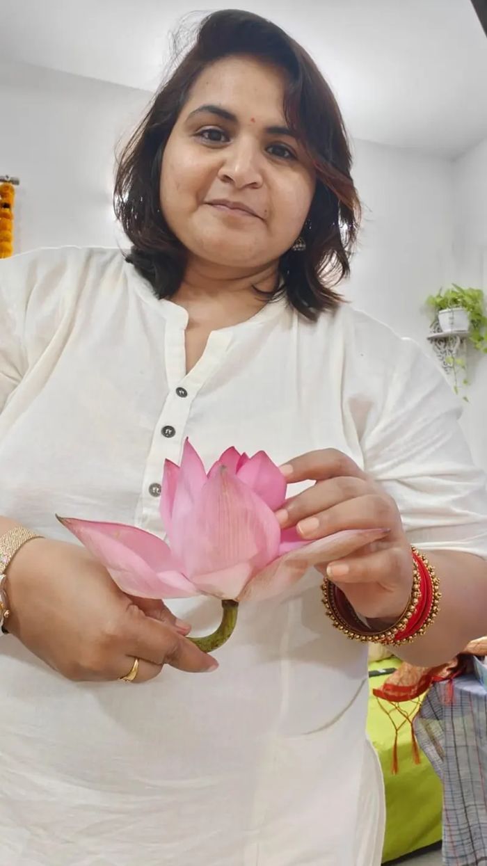 Neha Singla holding a pink lotus