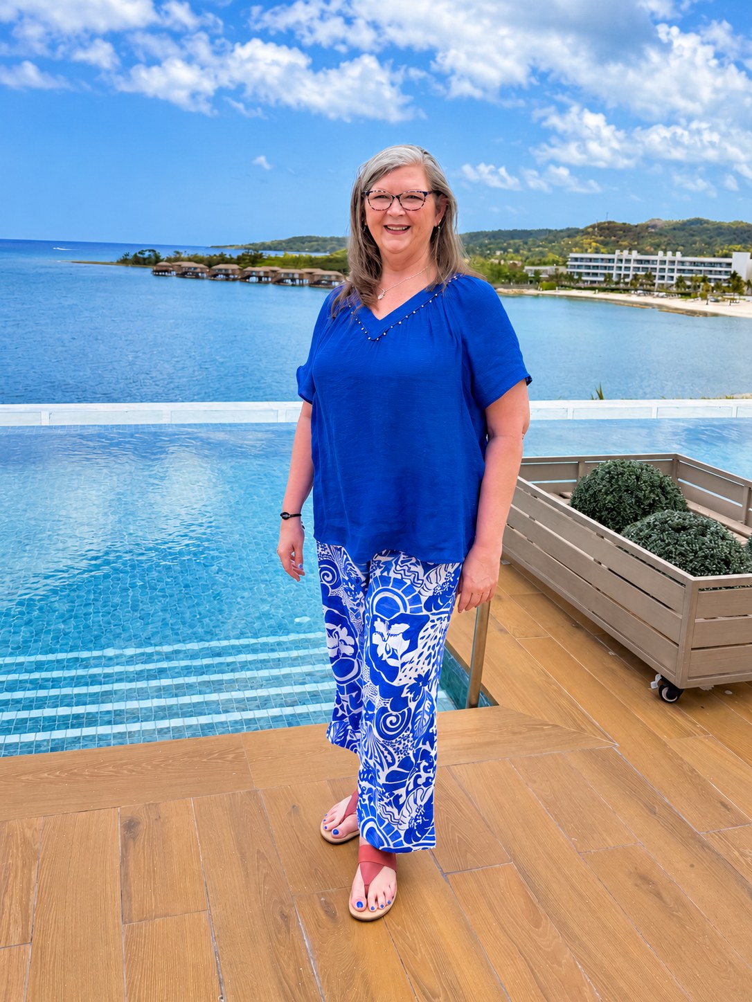 Jeni Chaffer, founder of Journey Down the Aisle, beside a resort pool overlooking the ocean.