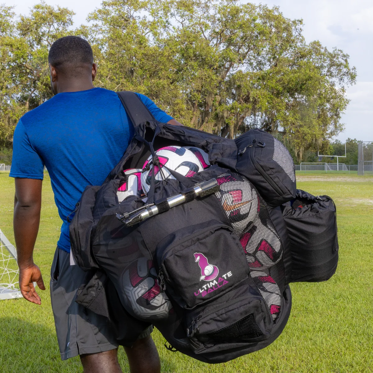 Coach carrying a loaded Ultimateballa soccer equipment bag over one shoulder