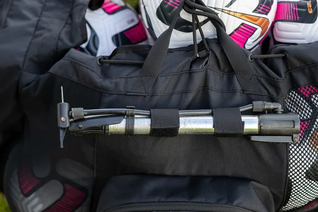 Folded training equipment secured to the outside of the bag