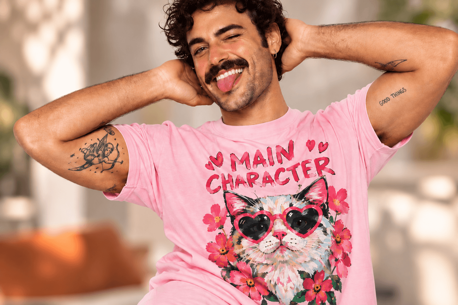 Man wearing a pink Odd Print Club cat graphic T-shirt with a bold playful design