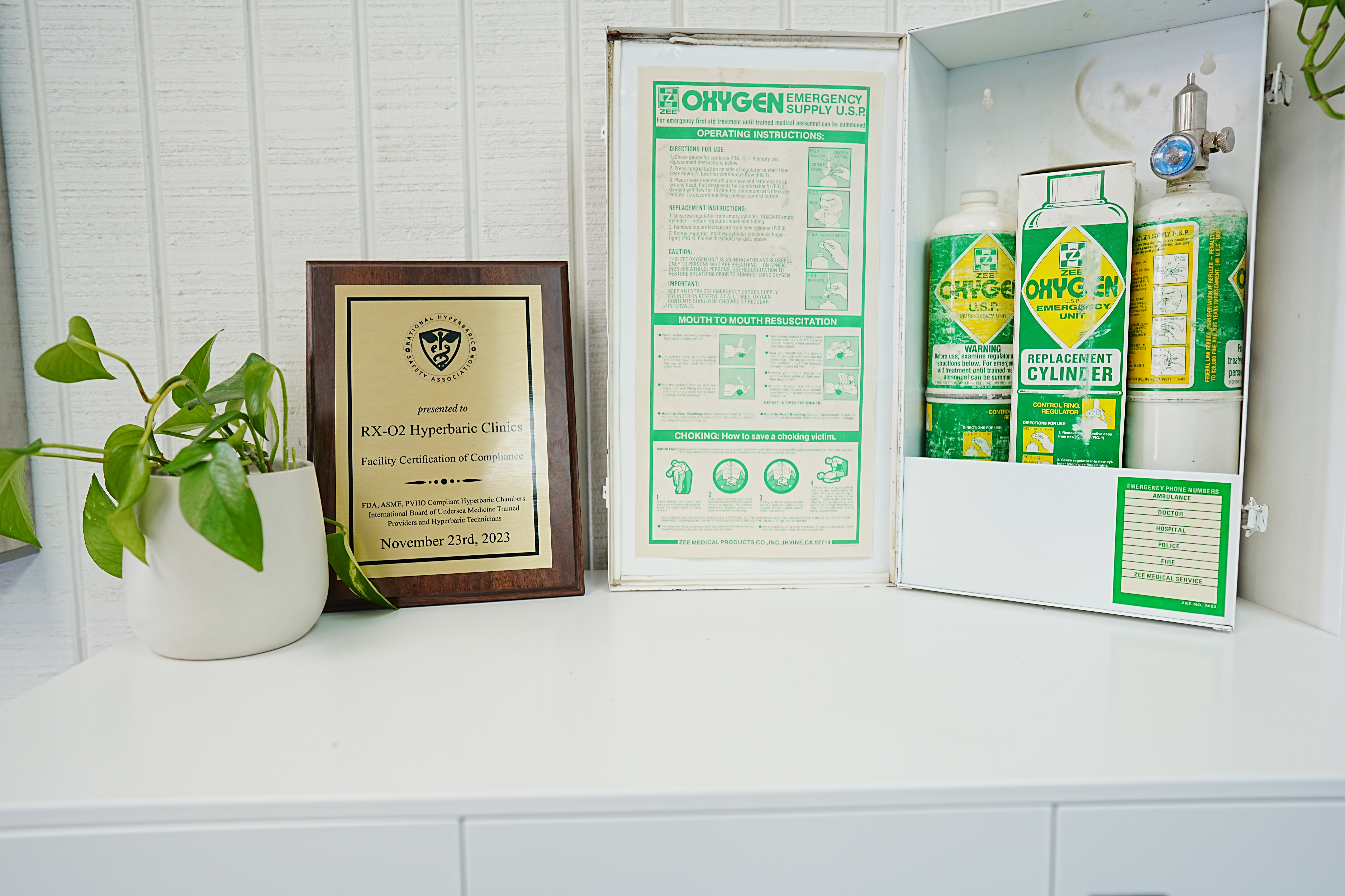 NHSA compliance certificate displayed beside emergency oxygen equipment at RX-O2