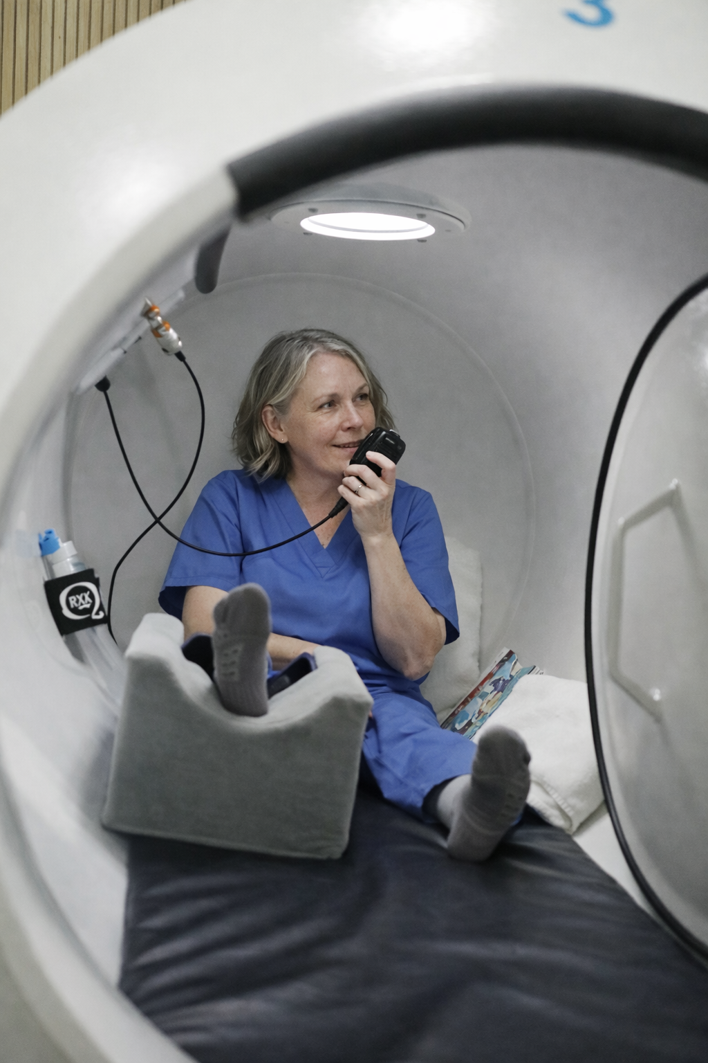 Patient reclining inside a chamber holding the communication handset