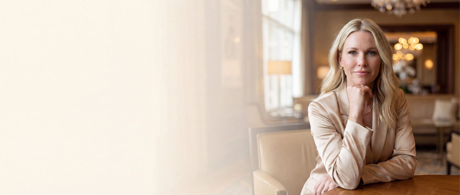 Ali Simpson seated at a table in a warm, softly lit lounge