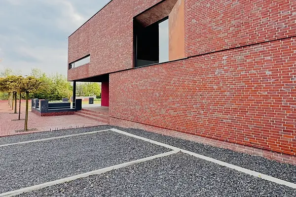 Seitenansicht des Office Park mit Klinkerfassade, Eingangsbereich und Bäumen