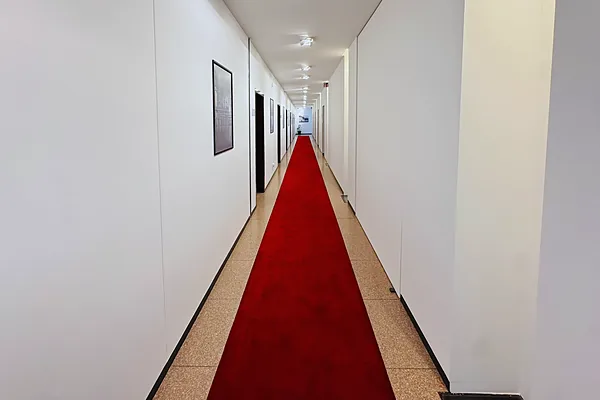 Heller Büroflur mit rotem Teppichläufer