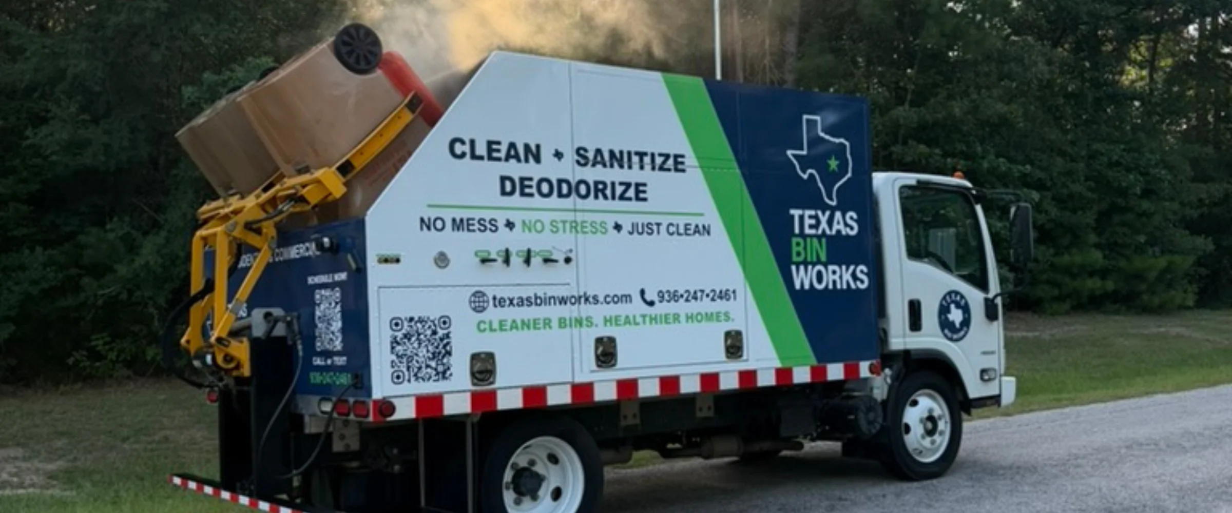 A Texas Bin Works truck cleaning a brown trash bin, with the 'Clean, Sanitize, Deodorize' slogan visible.