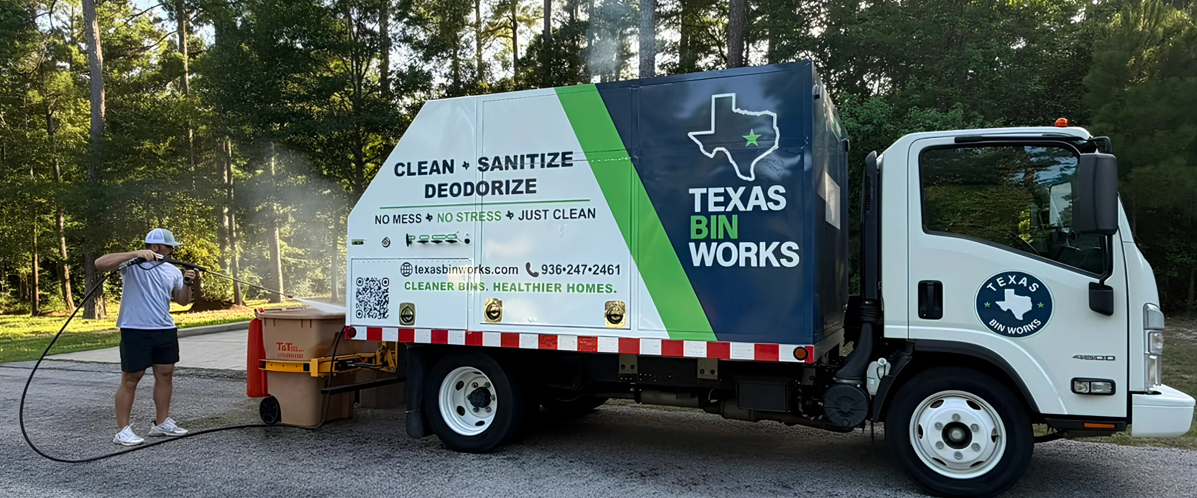 A Texas Bin Works truck with a green and blue logo lifting a large bin for cleaning, sanitizing, and deodorizing. A Texas Bin Works truck with a green and blue logo lifting a large bin for cleaning, sanitizing, and deodorizing.