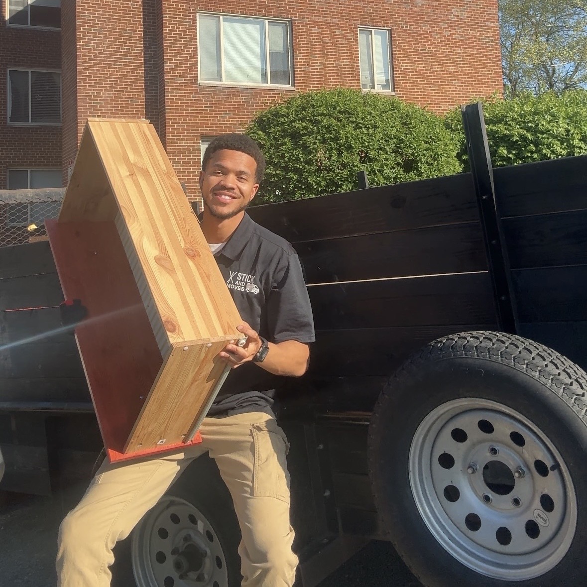 Team from Stick & Moves Junk Removal loading old furniture into a truck