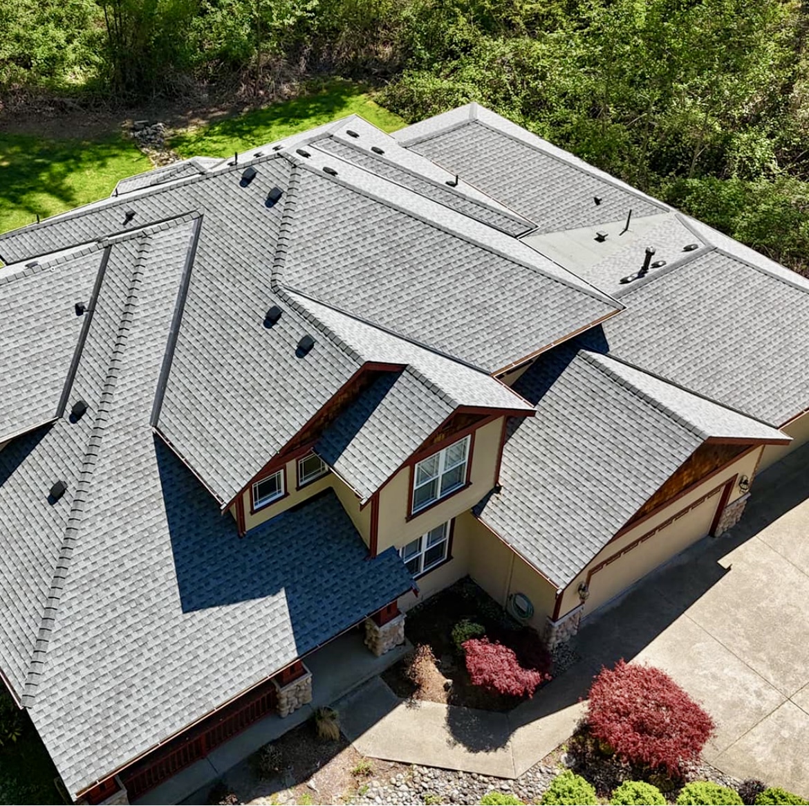 Roof repair contractor in Mississauga inspecting asphalt shingles on a residential home