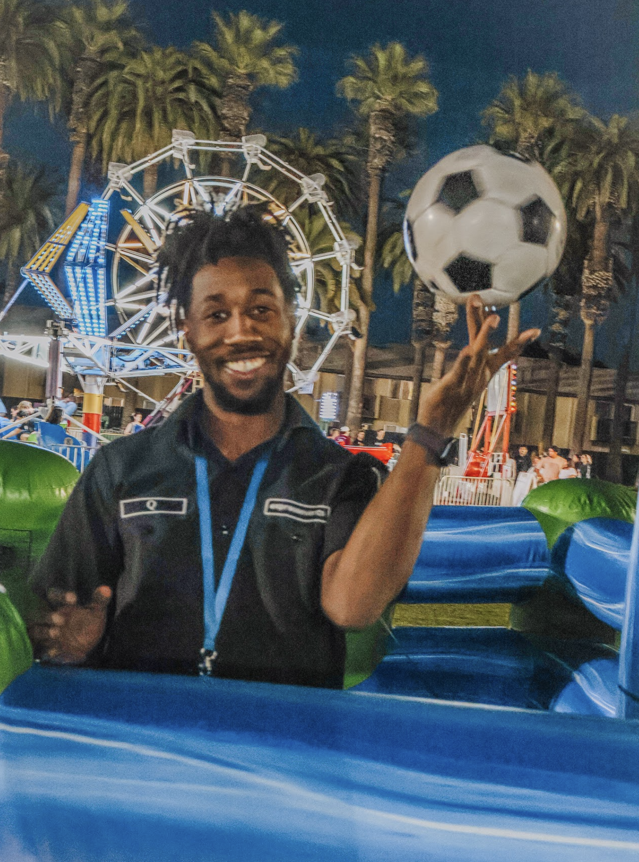 Friendly Express Events team member with a Human Foosball game and Ferris wheel in the background