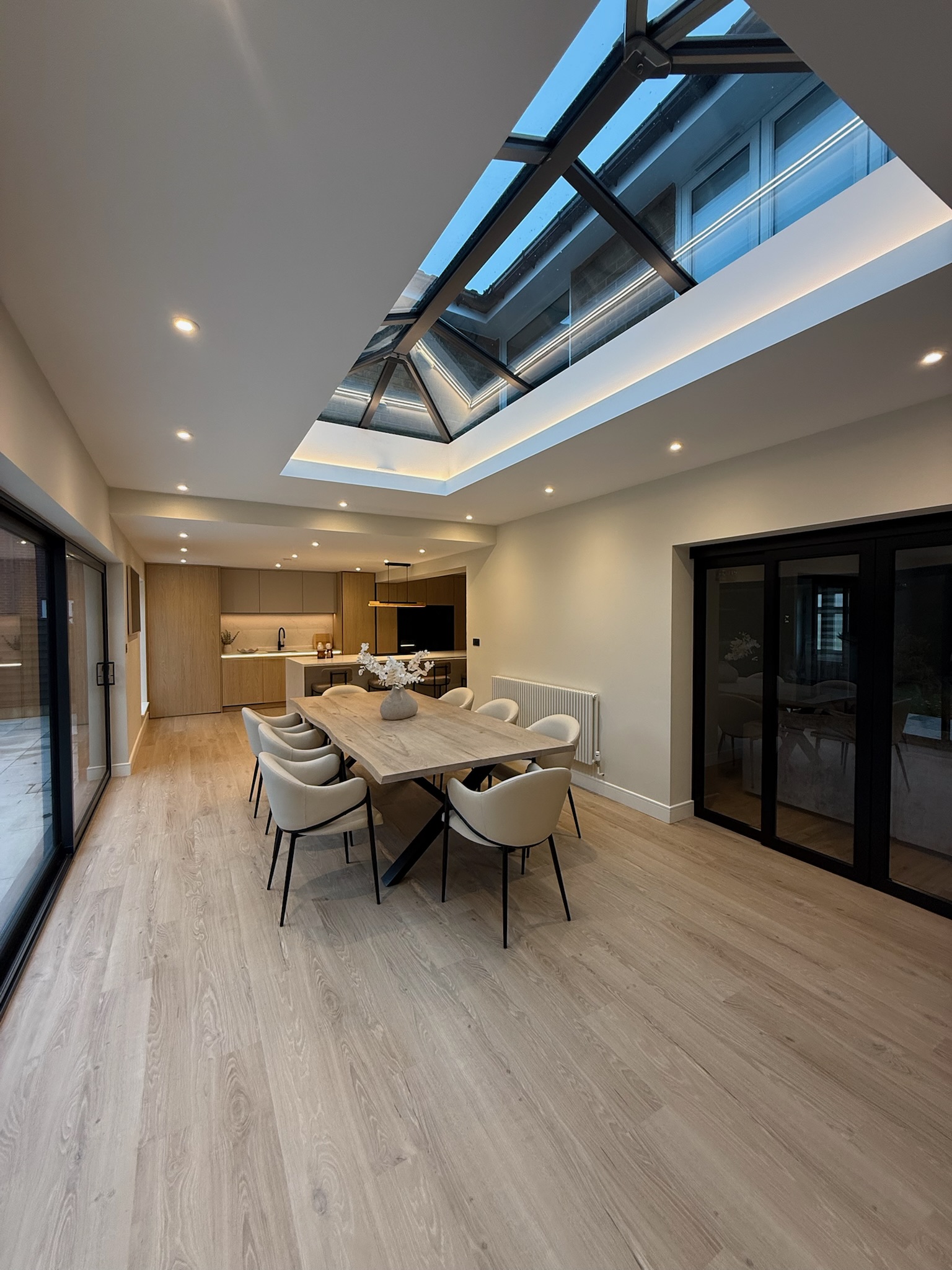 Modern rear extension in Rochdale with large roof lantern, open plan dining area and contemporary kitchen with natural wood finishes Modern rear extension in Rochdale with large roof lantern, open plan dining area and contemporary kitchen with natural wood finishes