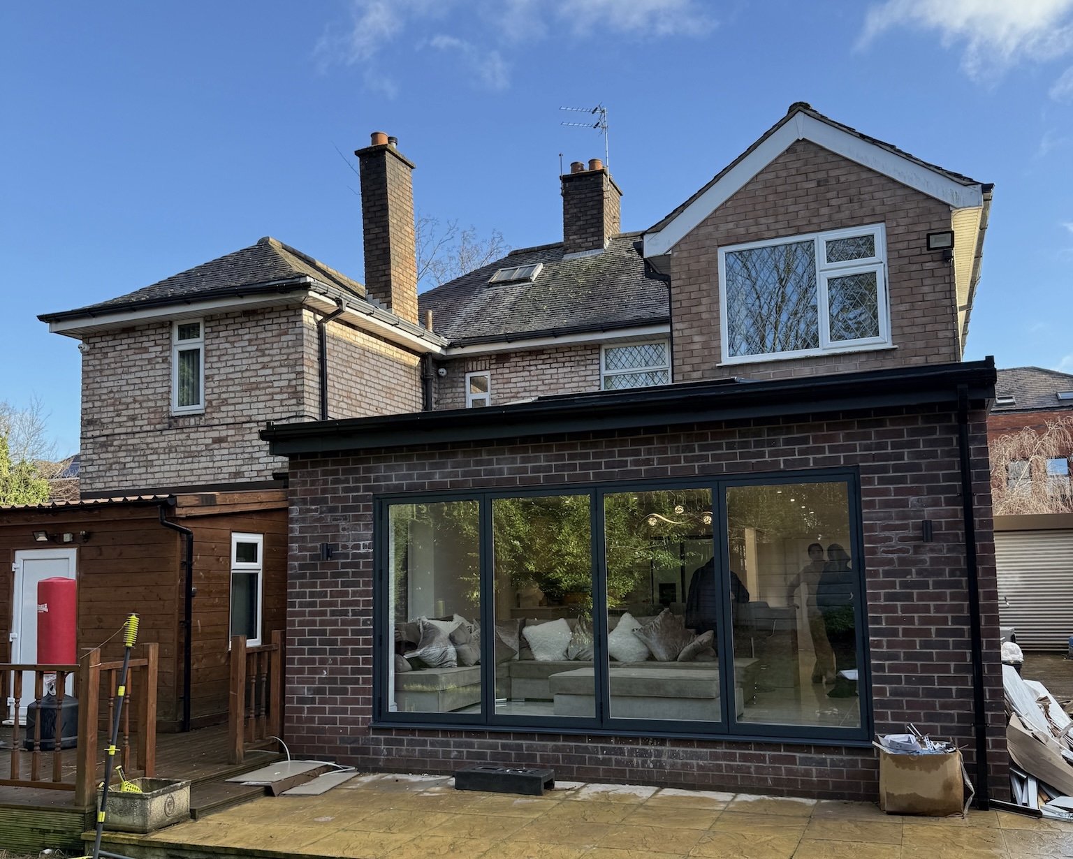 Rear house renovation and single storey extension in Whitefield with anthracite sliding doors and modern open plan living space Rear house renovation and single storey extension in Whitefield with anthracite sliding doors and modern open plan living space