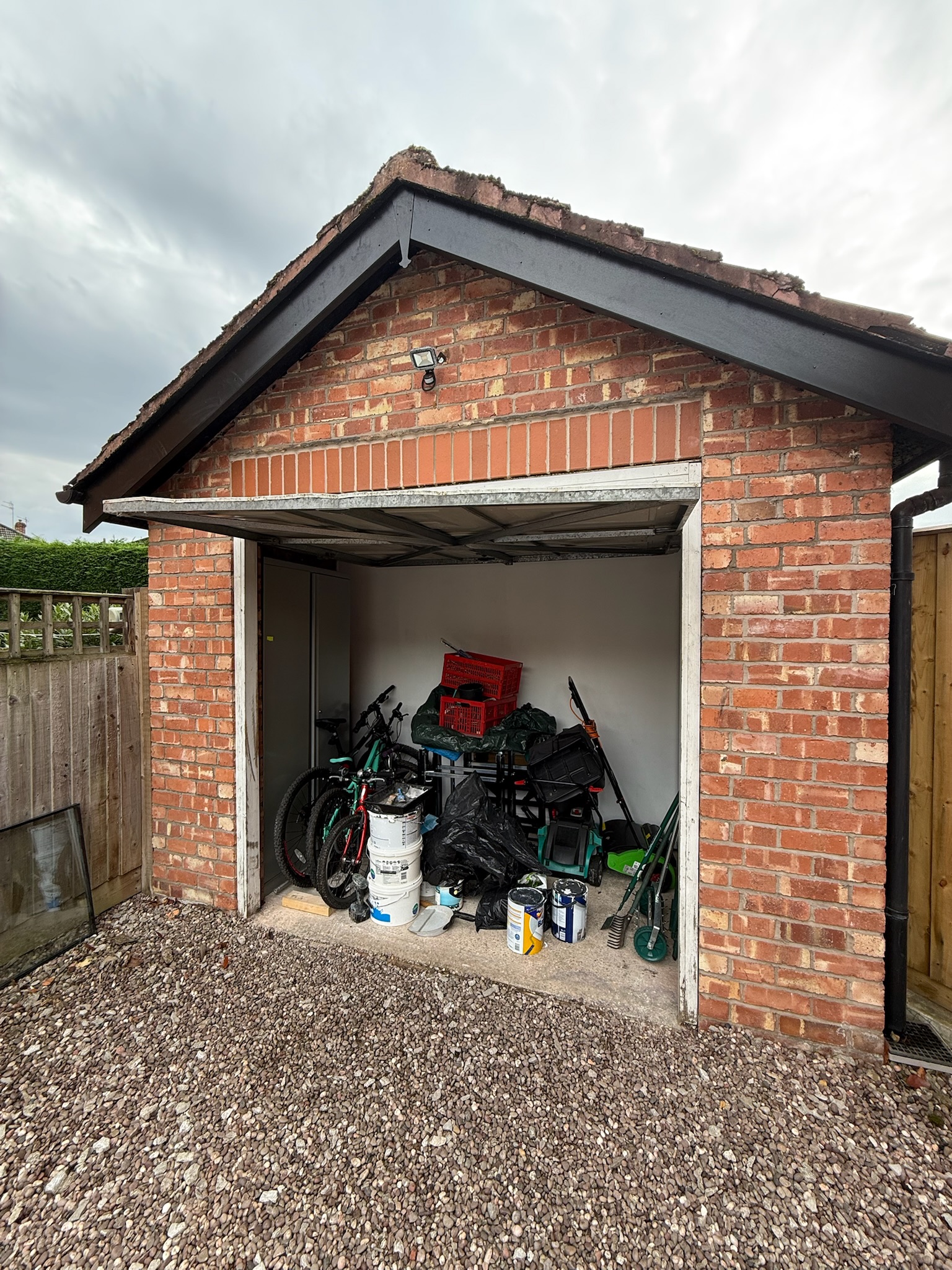 Detached garage conversion in Wilmslow with the original garage door retained and the front section kept as practical storage space Detached garage conversion in Wilmslow with the original garage door retained and the front section kept as practical storage space