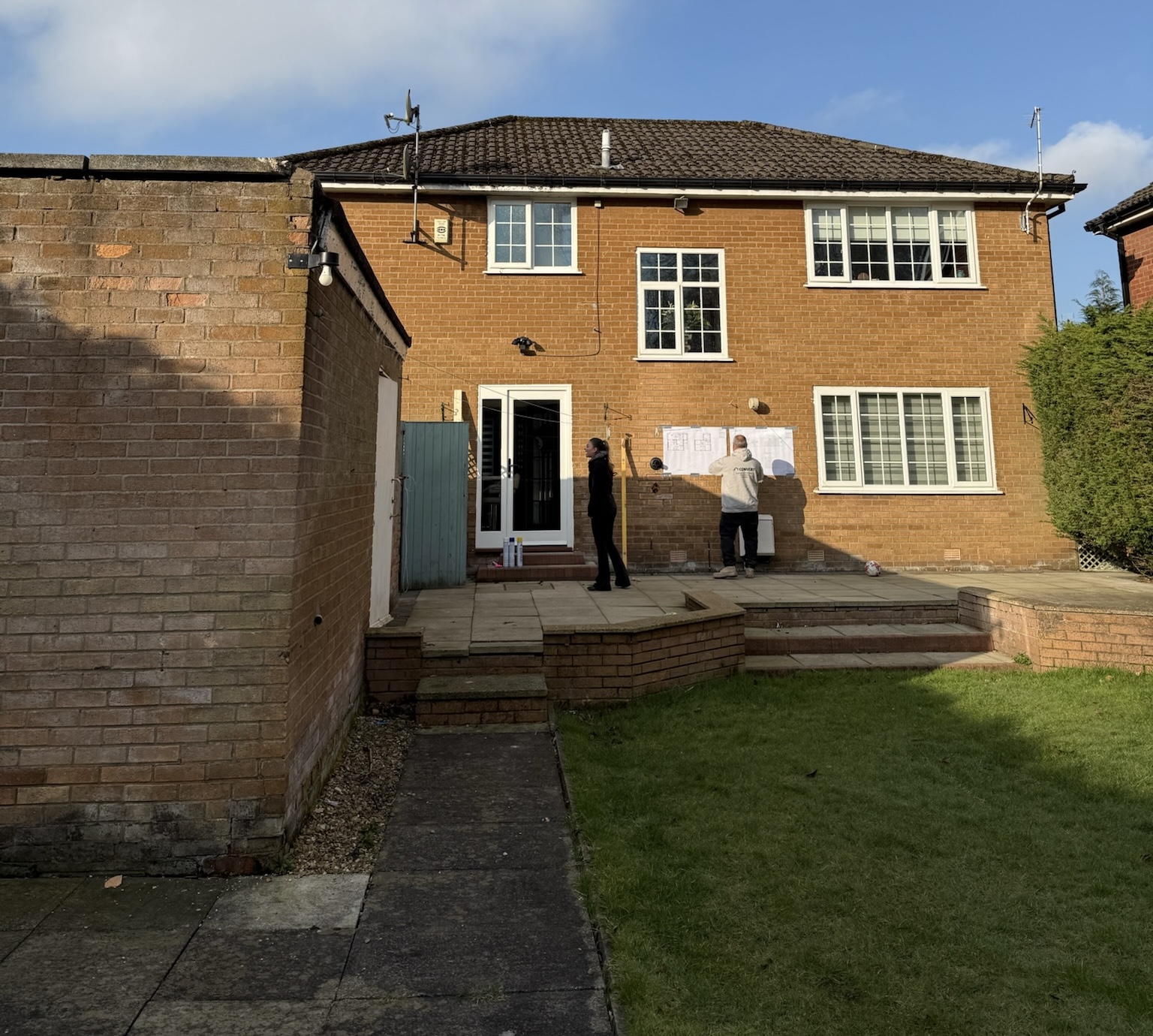 Planning stage of a rear home extension project with architectural drawings and on site preparation before construction begins Planning stage of a rear home extension project with architectural drawings and on site preparation before construction begins