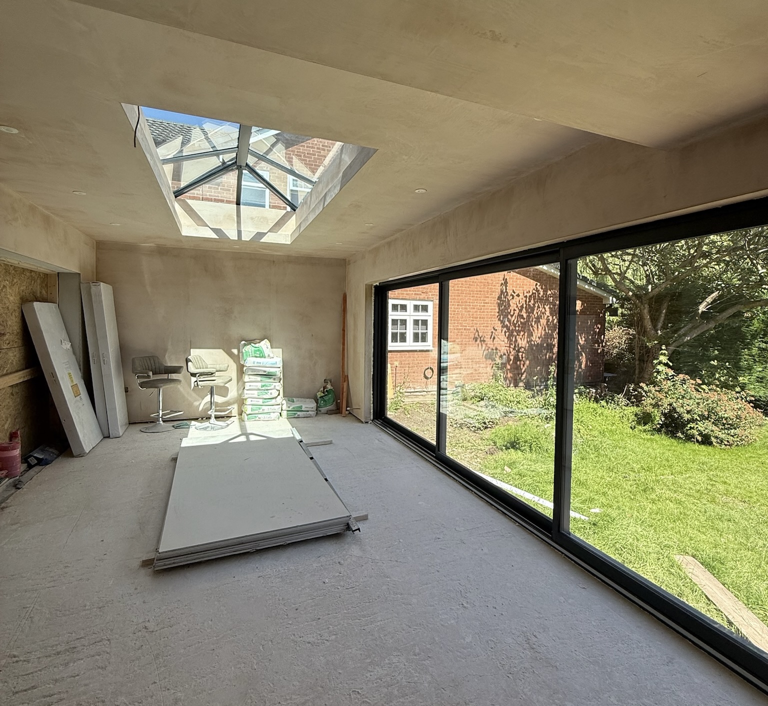 Rear house extension during the first fix stage with installed roof lantern, large sliding doors, plasterboarding and internal preparation work underway Rear house extension during the first fix stage with installed roof lantern, large sliding doors, plasterboarding and internal preparation work underway