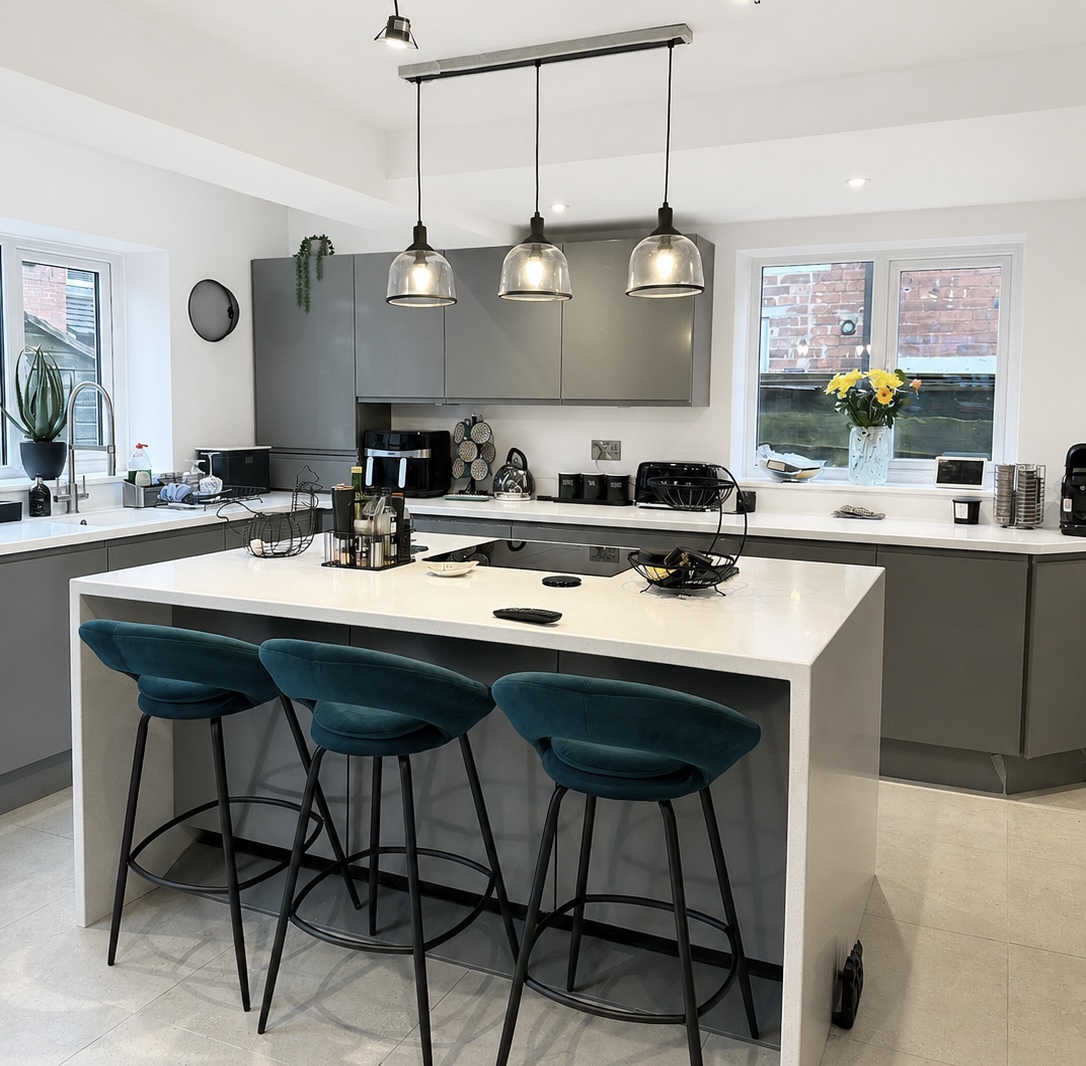 Modern kitchen extension in Prestwich with large kitchen island, pendant lighting, breakfast bar seating and open plan layout
