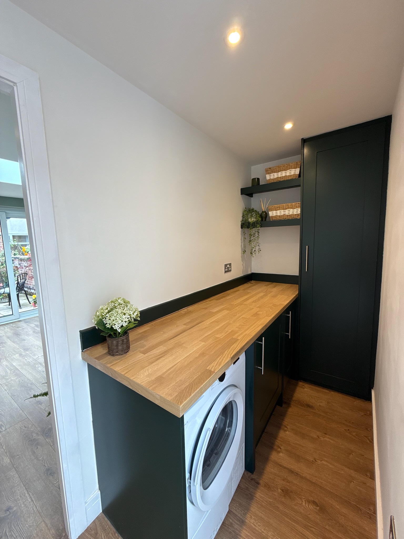 Detached garage conversion in Failsworth featuring a modern utility room with fitted storage, oak worktops and integrated washing machine Detached garage conversion in Failsworth featuring a modern utility room with fitted storage, oak worktops and integrated washing machine