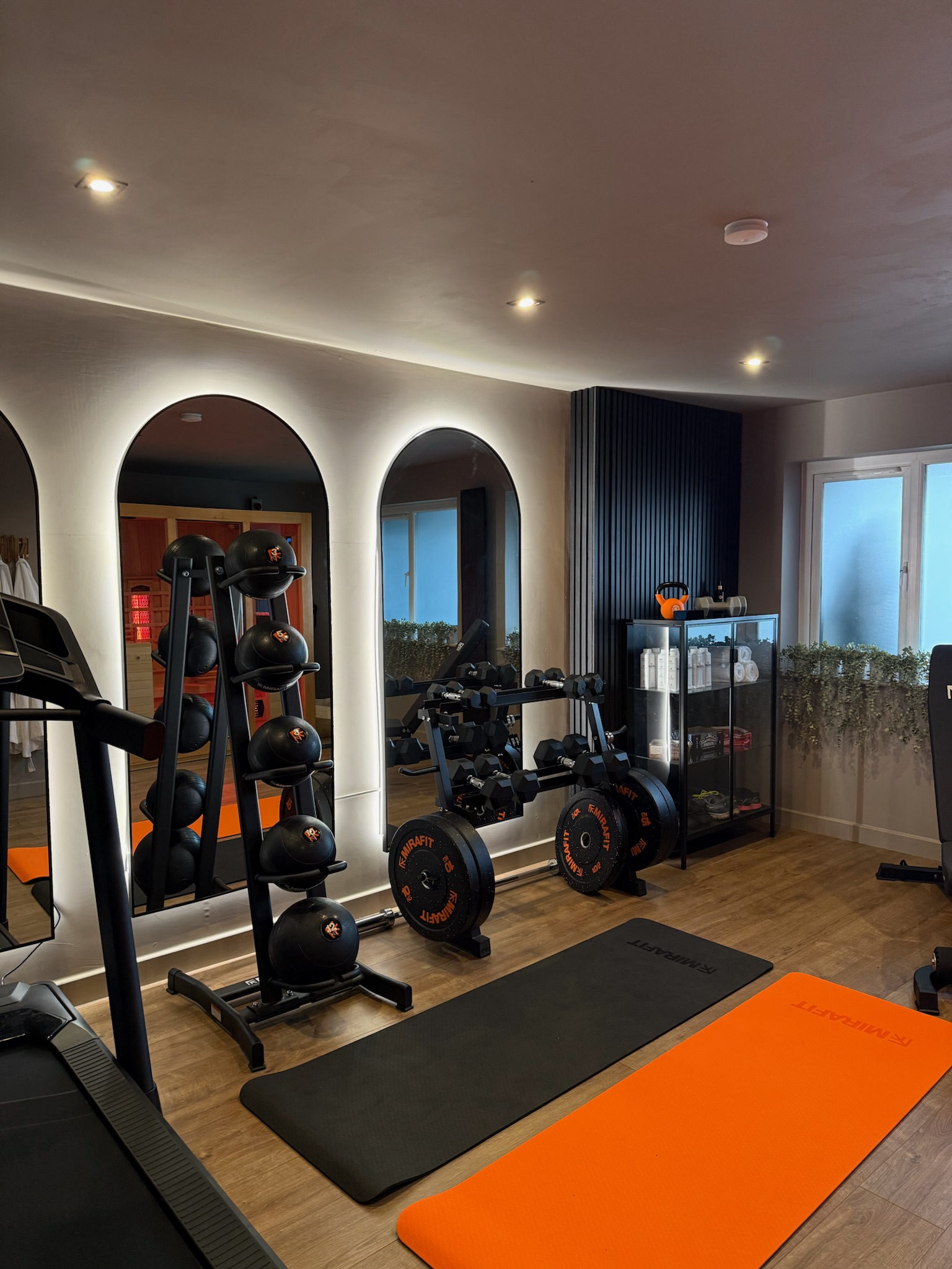 Garage conversion completed in Bury transformed into a luxury home gym with feature lighting, mirrored walls, gym flooring and modern black acoustic panel detailing Garage conversion completed in Bury transformed into a luxury home gym with feature lighting, mirrored walls, gym flooring and modern black acoustic panel detailing