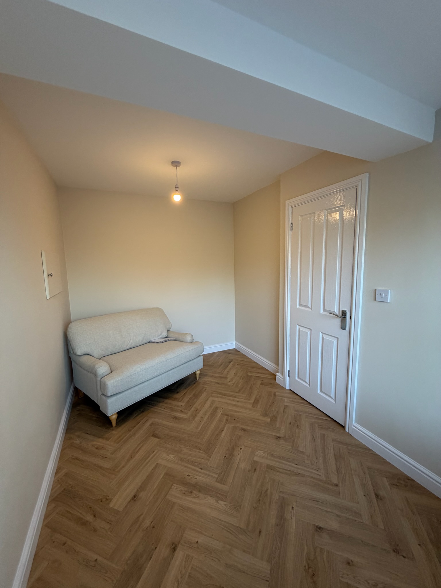 Garage conversion completed in Accrington transformed into a cosy snug room with herringbone flooring, neutral décor and additional living space Garage conversion completed in Accrington transformed into a cosy snug room with herringbone flooring, neutral décor and additional living space