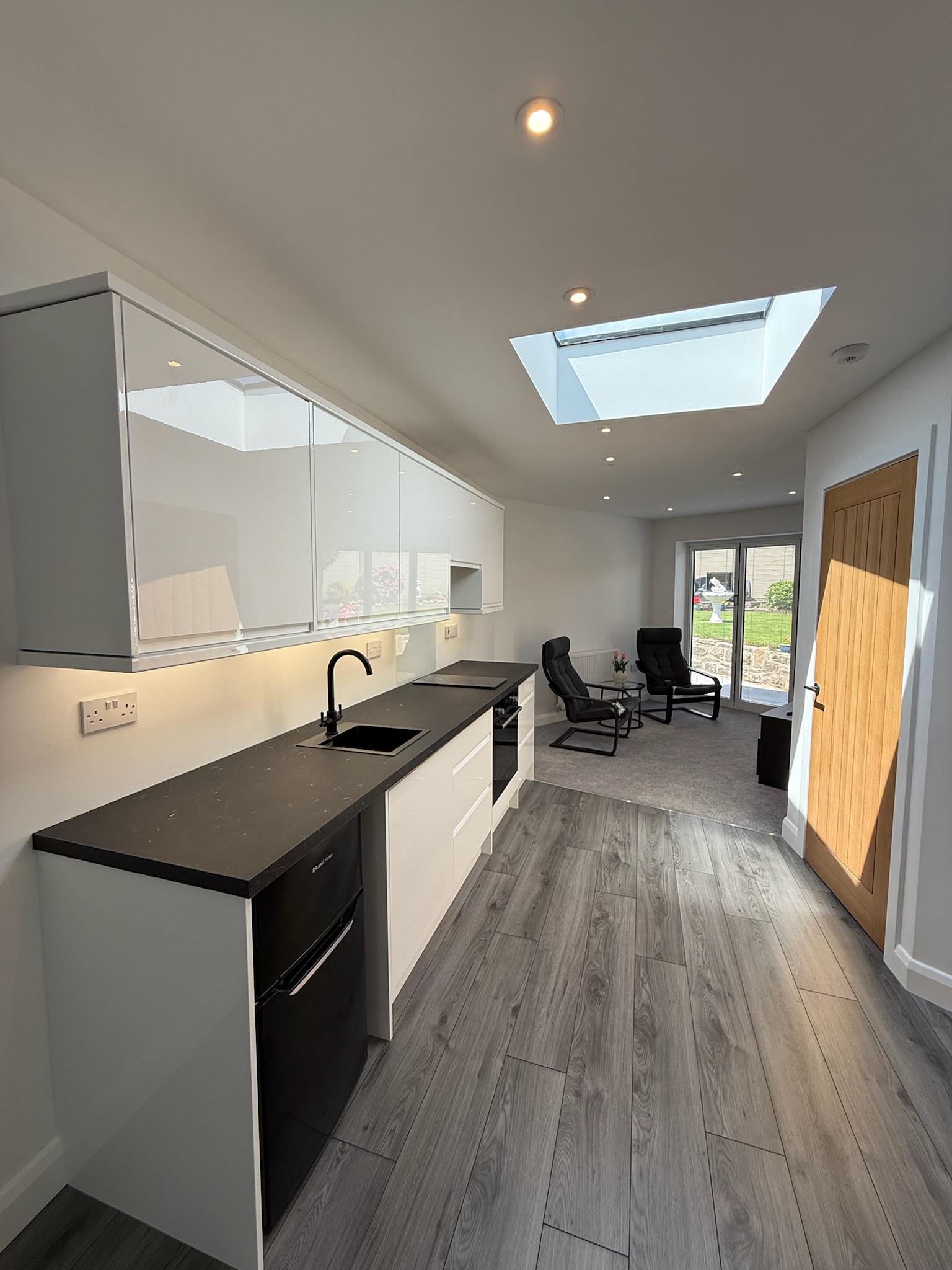 Side extension in Rochdale converted into a self contained annexe with fitted kitchen, bedroom, bathroom, skylights, private entrance and sliding doors opening onto the garden.