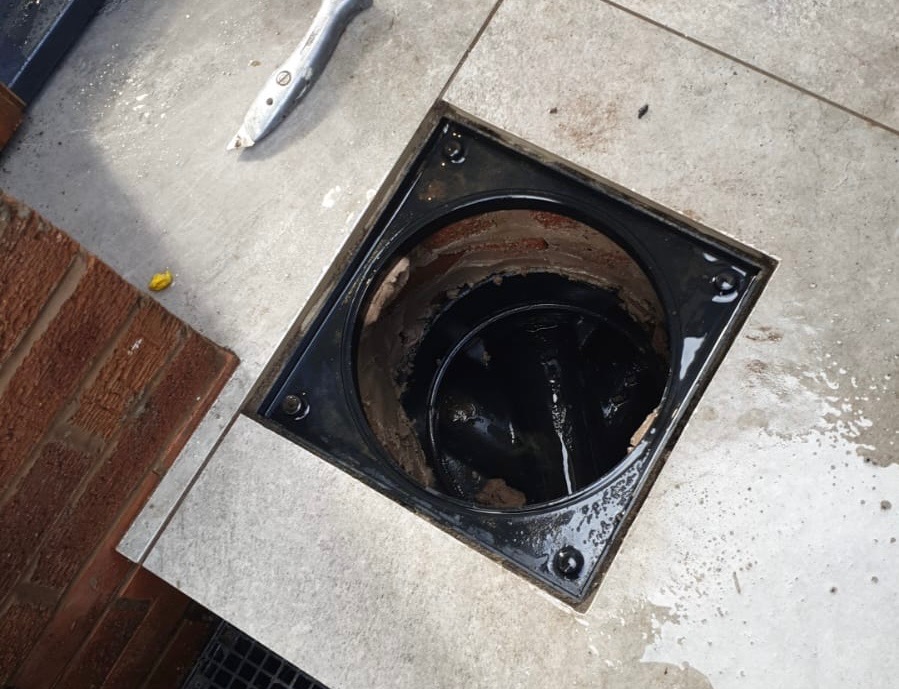 Access chamber inside a garage conversion showing maintained drainage access beneath the floor. Access chamber inside a garage conversion showing maintained drainage access beneath the floor.