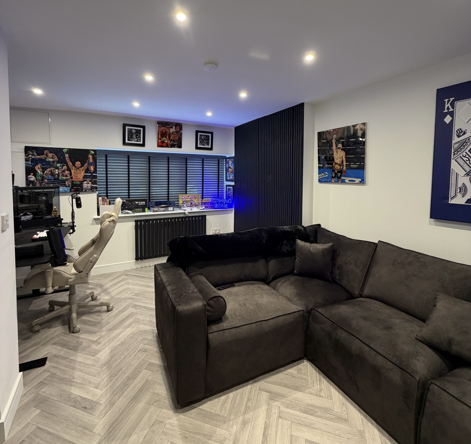 Garage conversion in Middleton transformed into a games room with gaming setup, lounge area, feature slat wall, herringbone flooring and modern lighting. Garage conversion in Middleton transformed into a games room with gaming setup, lounge area, feature slat wall, herringbone flooring and modern lighting.