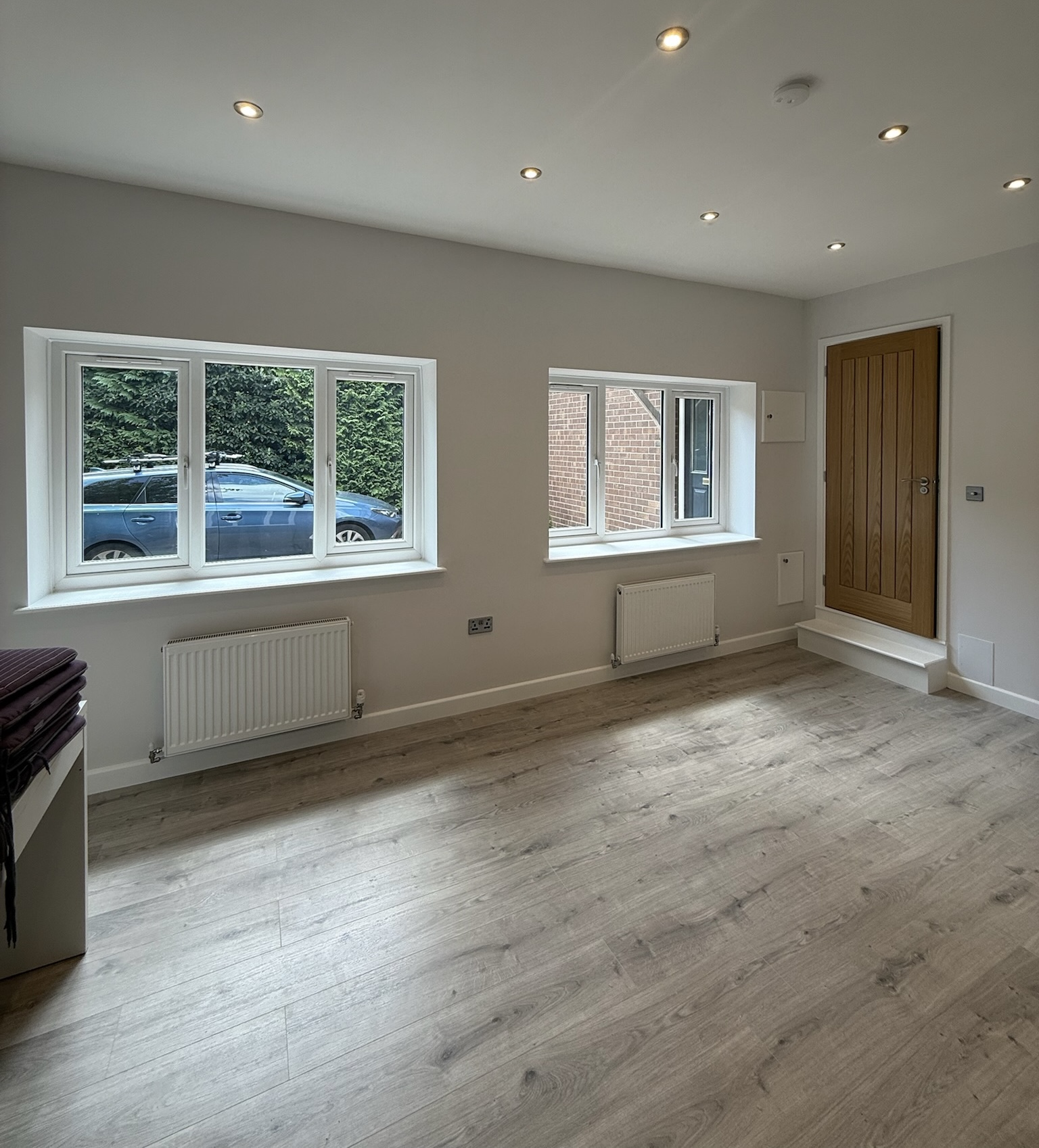 Double garage conversion in Altrincham transformed into a bright living space with two new windows, modern flooring, recessed lighting and fully insulated walls. Double garage conversion in Altrincham transformed into a bright living space with two new windows, modern flooring, recessed lighting and fully insulated walls.