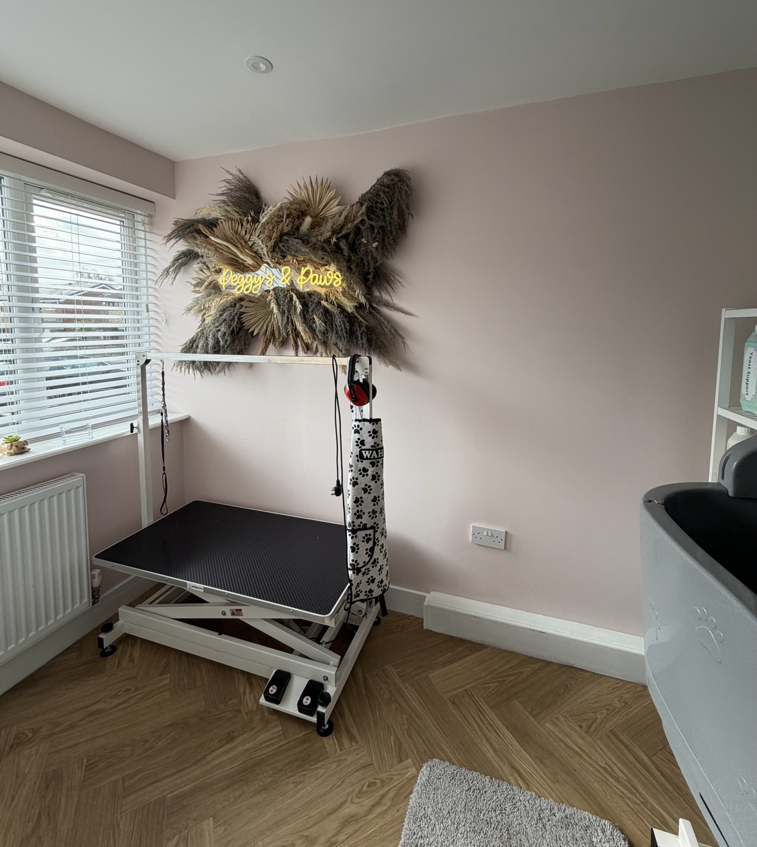 Single garage conversion in Bolton transformed into a professional dog grooming salon with herringbone flooring, grooming table, natural light and a dedicated workspace for a home based dog grooming business.