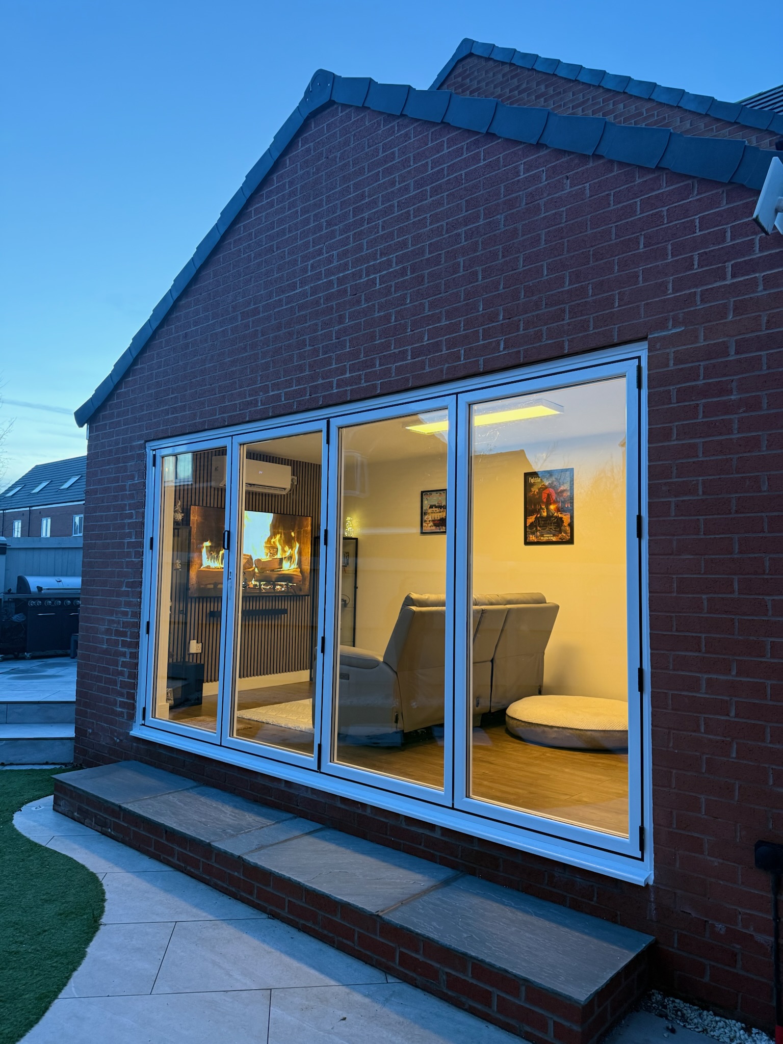 Detached single brick garage converted into a snug and home office in Wigan with large aluminium bifold doors.