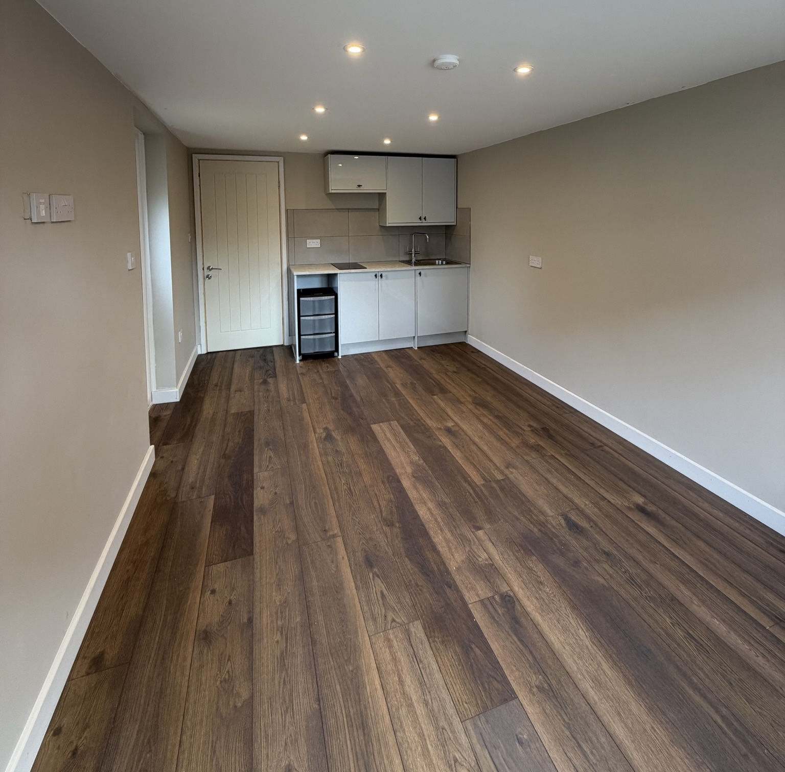 Detached garage conversion in Stockport transformed into a self contained granny annexe with a fitted kitchenette, bedroom and private bathroom, creating comfortable independent living space for a family member.