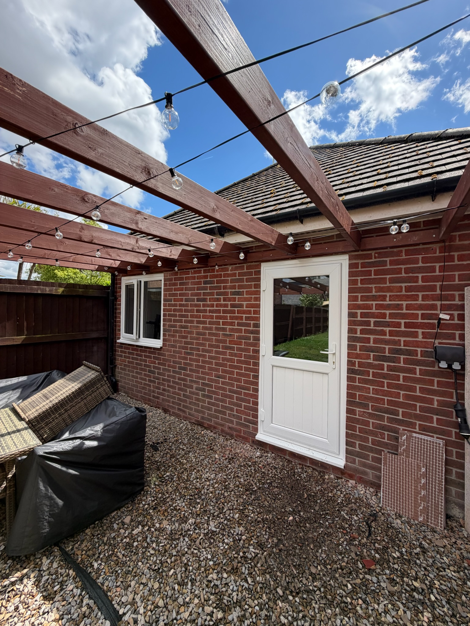 Exterior of a detached garage conversion in Chadderton transformed into a self contained annexe with an en suite, featuring matching brickwork, white uPVC windows and door, creating comfortable independent living space for a family member