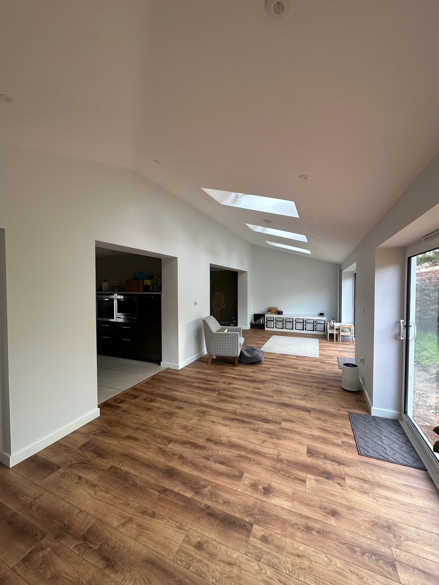 Rear house extension in Radcliffe creating a spacious open plan kitchen and living room with rooflights, vaulted ceiling and large sliding doors.