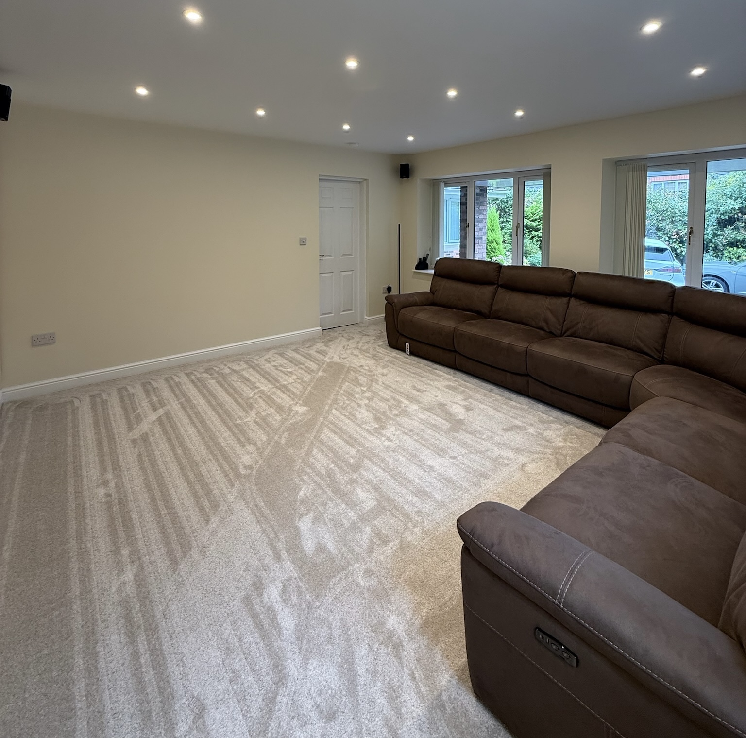 Double garage conversion in Rochdale transformed into a spacious living room with media wall, large windows, recessed lighting and fitted carpet. Double garage conversion in Rochdale transformed into a spacious living room with media wall, large windows, recessed lighting and fitted carpet.