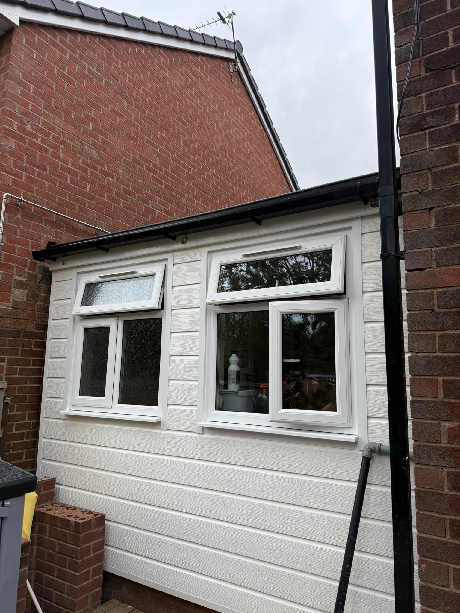 Exterior of an attached single garage conversion in Oldham, converted into a second living room with new windows. Exterior of an attached single garage conversion in Oldham, converted into a second living room with new windows.