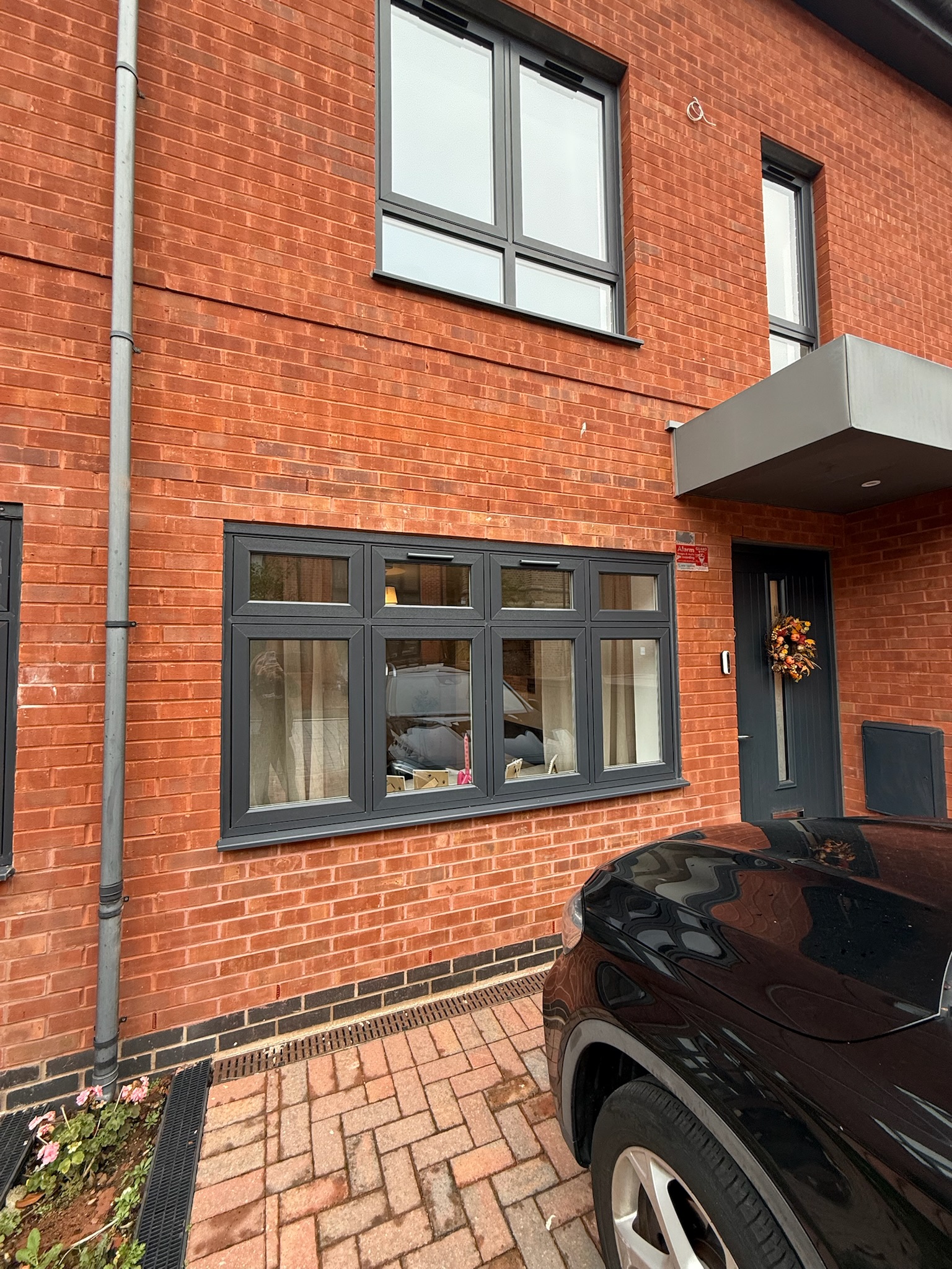Exterior of a single attached garage conversion in Stockport, with the former garage door replaced by brickwork and a large window. Exterior of a single attached garage conversion in Stockport, with the former garage door replaced by brickwork and a large window.