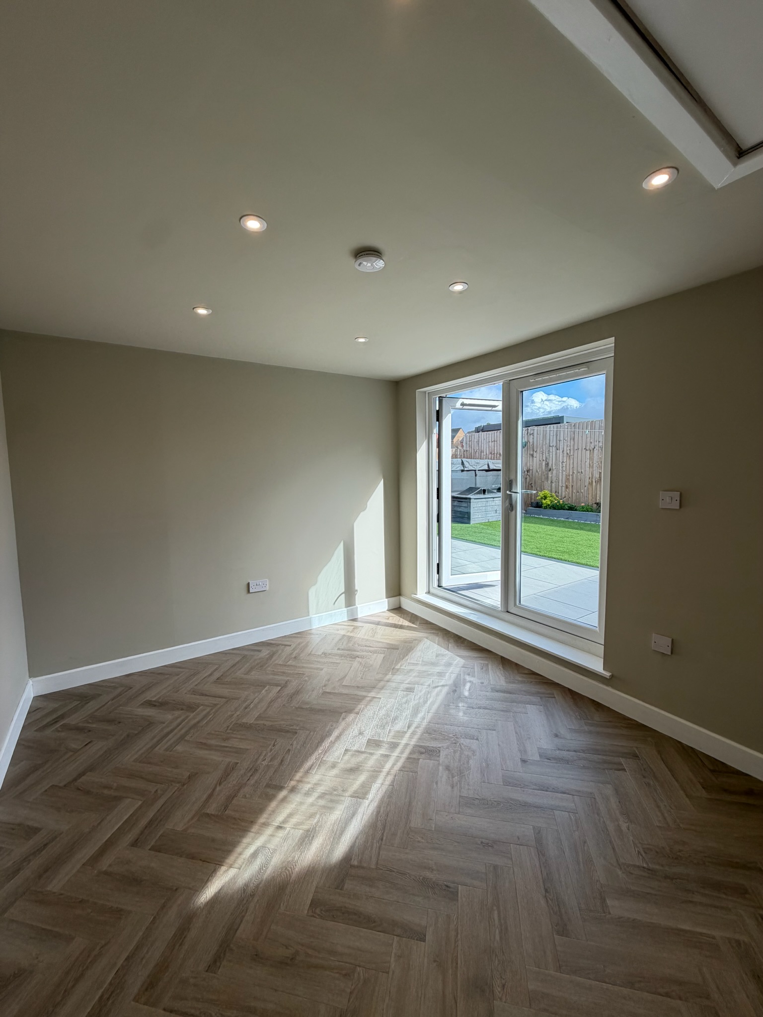 Detached single garage conversion in Atherton with herringbone style flooring, French doors and a bright finished interior. Detached single garage conversion in Atherton with herringbone style flooring, French doors and a bright finished interior.
