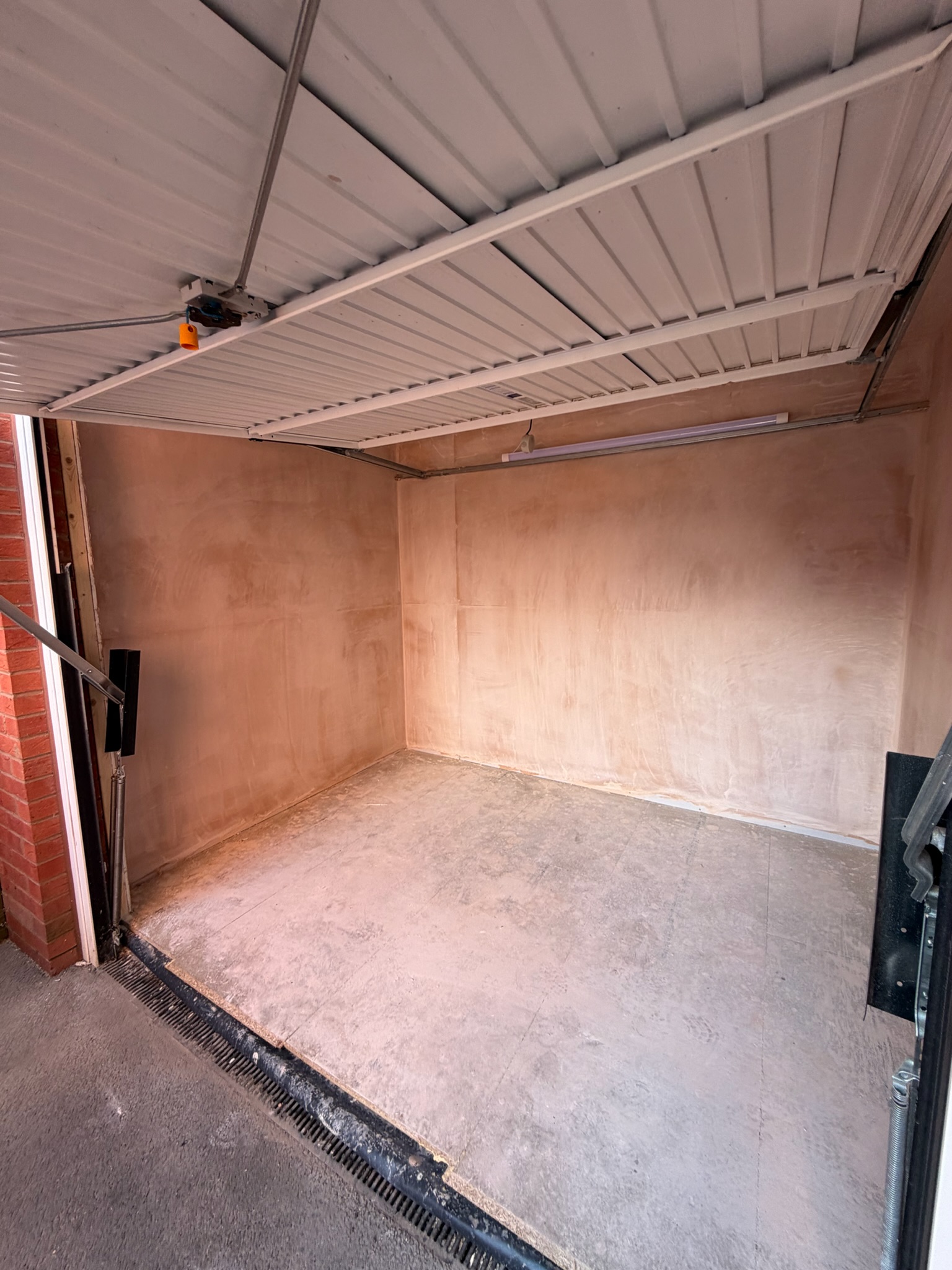 Single garage conversion in Wigan after plastering, showing the room nearing the finishing stages before decoration and flooring are completed.