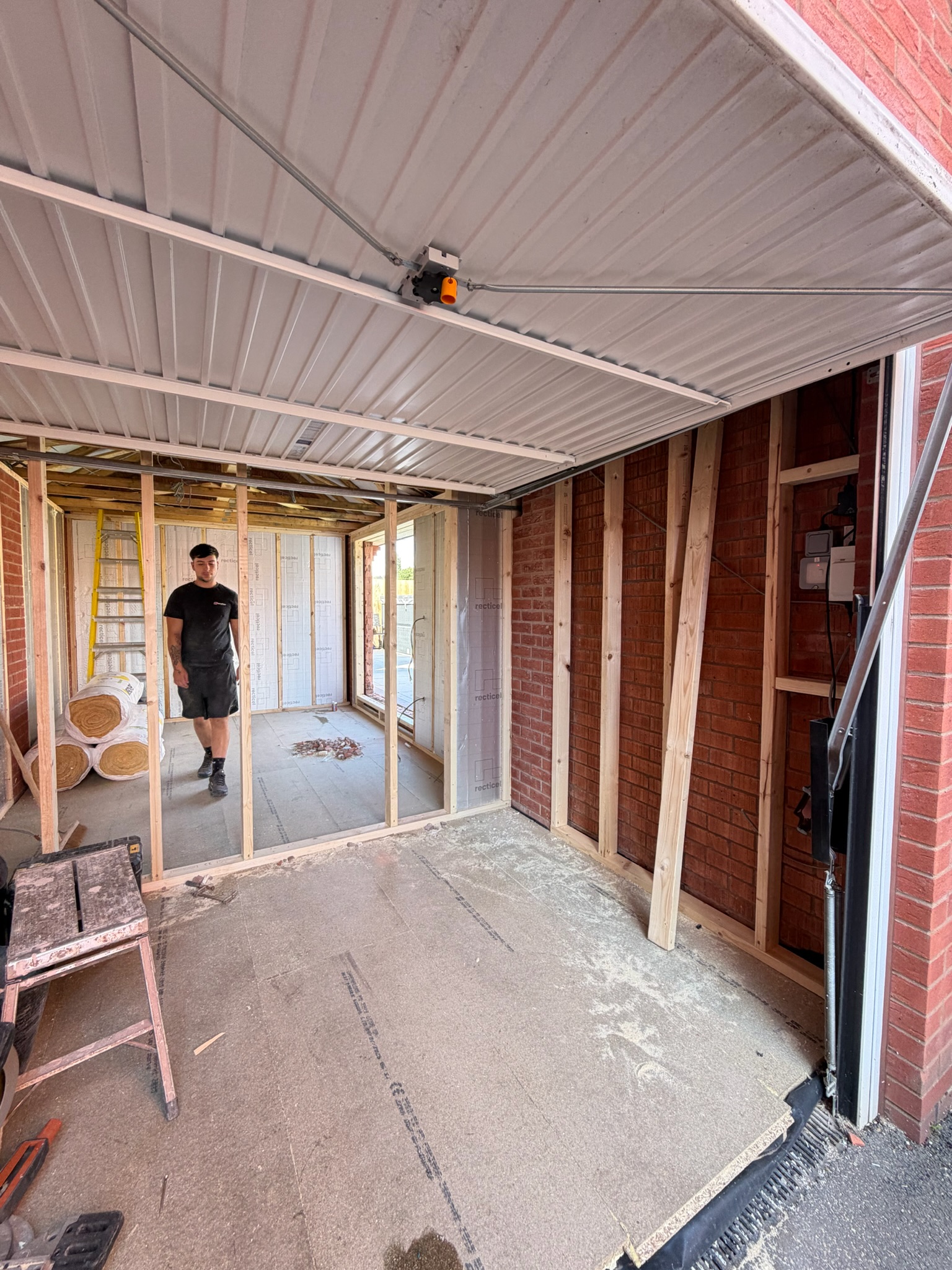 Wigan single garage conversion during construction with timber studwork, insulation and a new partition being installed before the walls are closed.