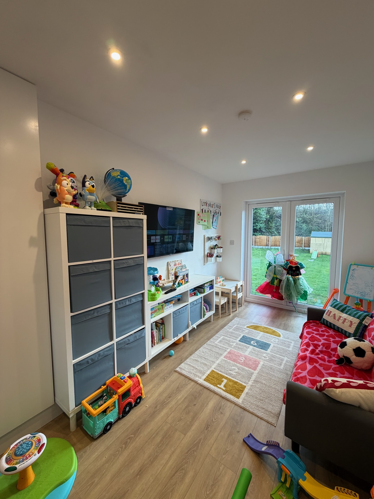 Double garage conversion in Radcliffe transformed into a utility room and children’s playroom with television, storage and open floor space. Double garage conversion in Radcliffe transformed into a utility room and children’s playroom with television, storage and open floor space.