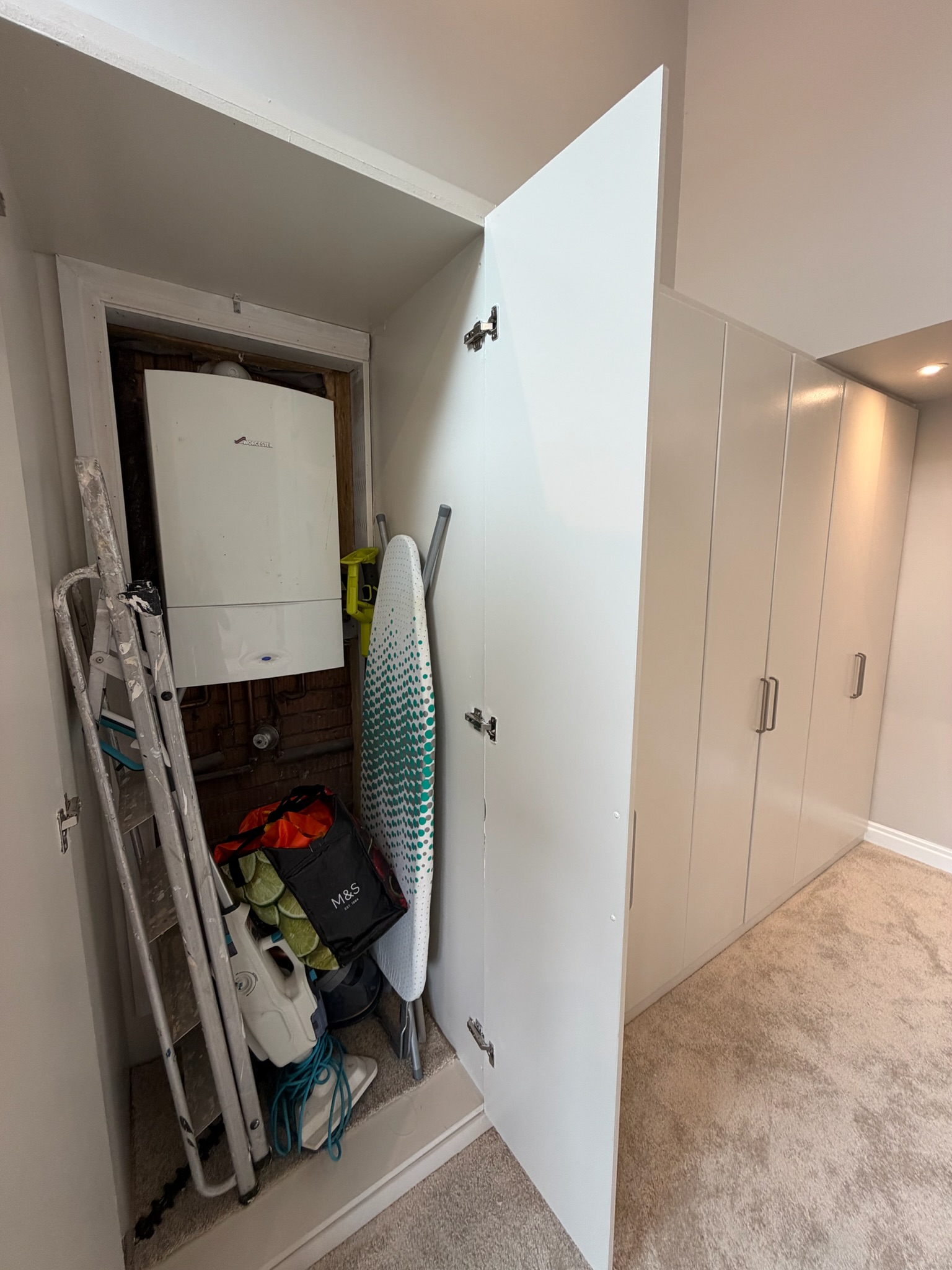 Double garage conversion in Bolton transformed into a living room, with a separate cupboard housing an existing boiler alongside fitted storage. Double garage conversion in Bolton transformed into a living room, with a separate cupboard housing an existing boiler alongside fitted storage.