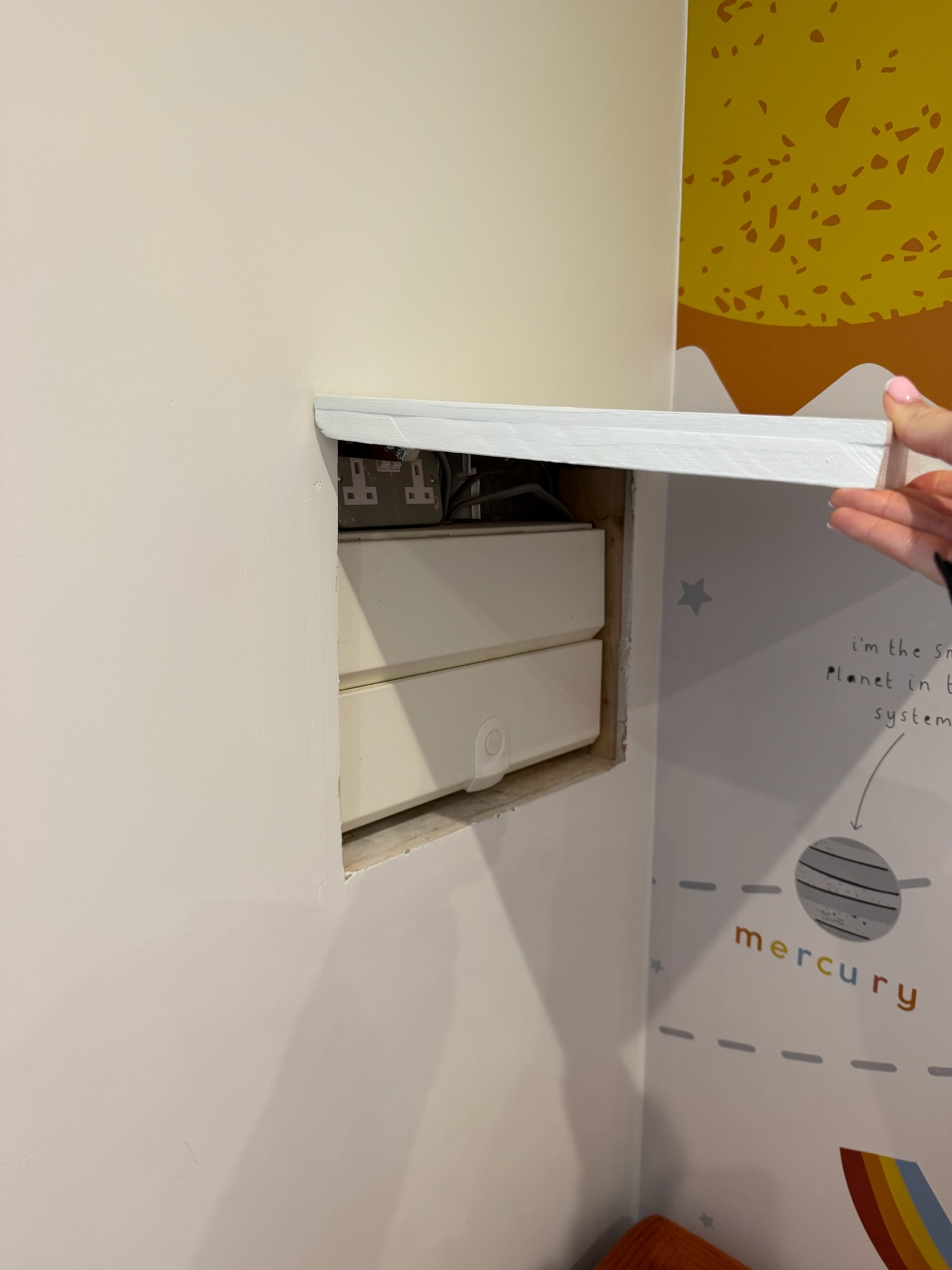 Single garage conversion in Wigan transformed into a playroom, with a removable wall access panel revealing existing electrical equipment. Single garage conversion in Wigan transformed into a playroom, with a removable wall access panel revealing existing electrical equipment.