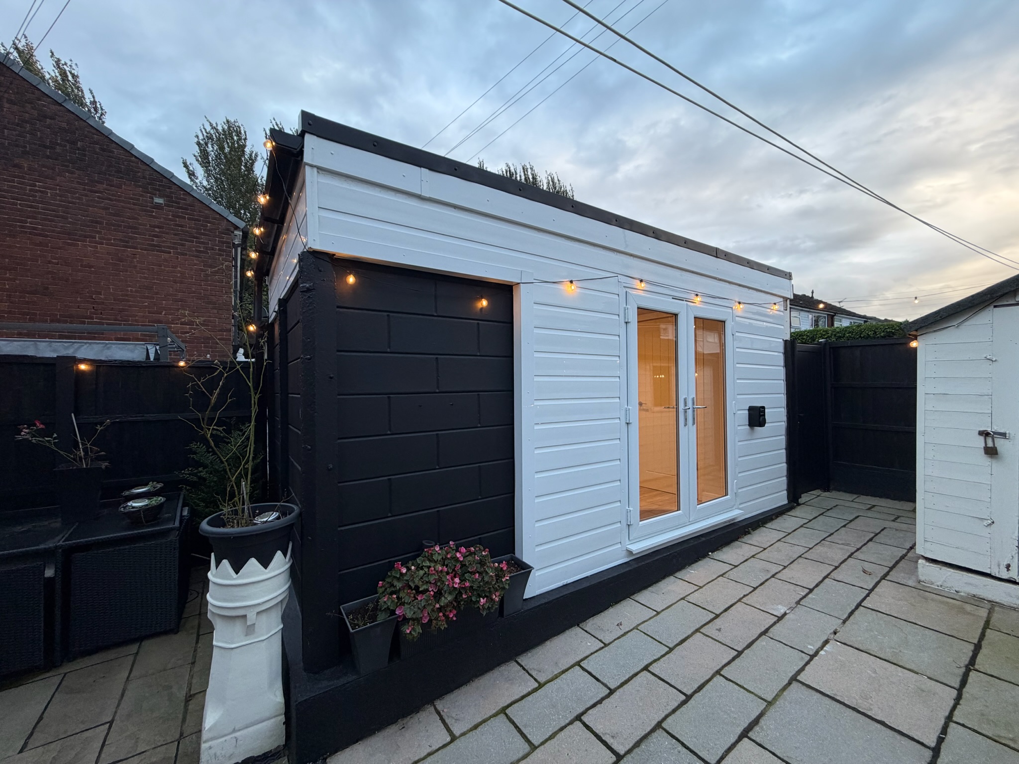 Single garage conversion in Bury transformed into a home office with storage, featuring white exterior cladding, contrasting black finishes and French doors. Single garage conversion in Bury transformed into a home office with storage, featuring white exterior cladding, contrasting black finishes and French doors.