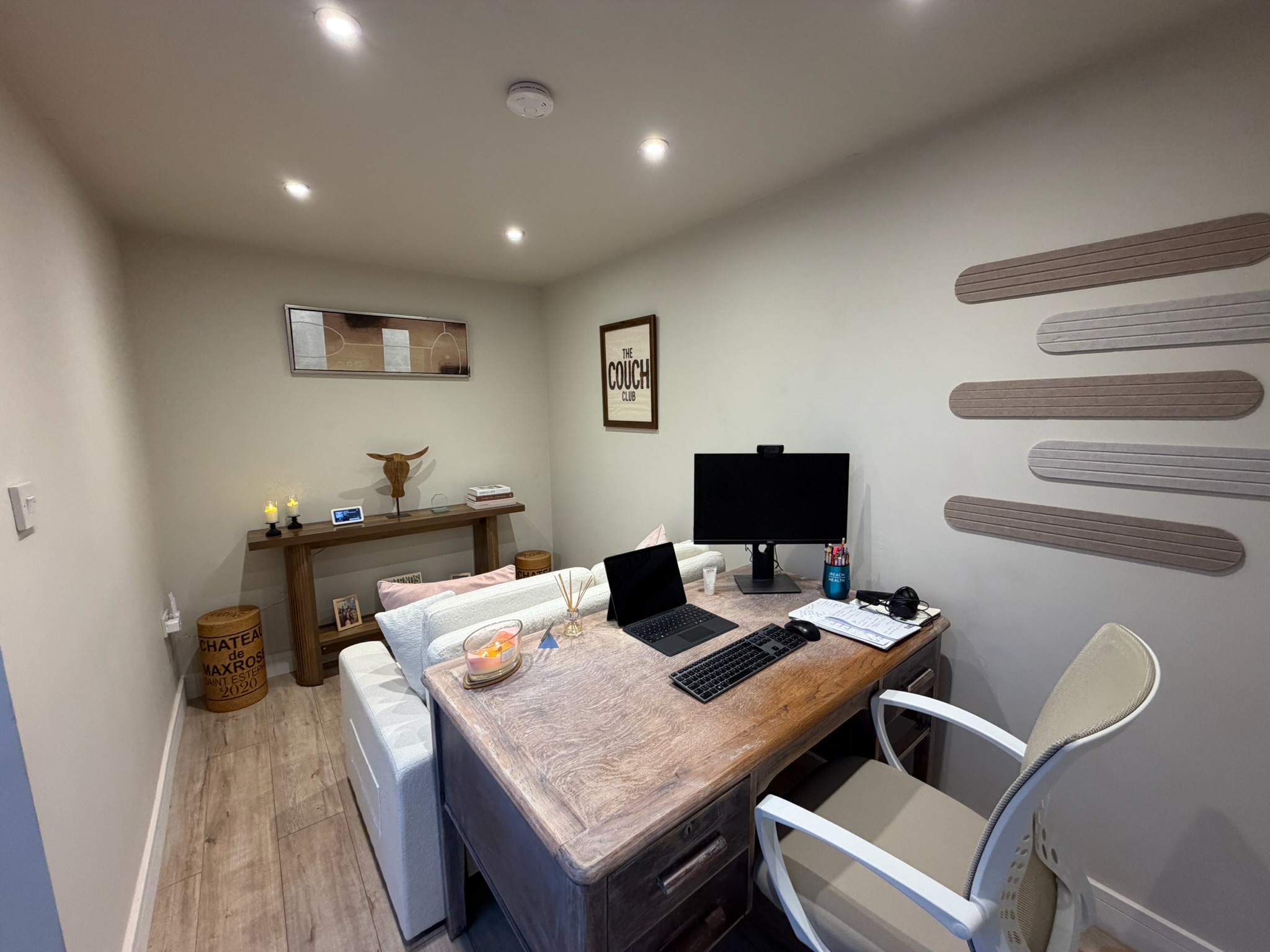 Detached single garage conversion in Bury transformed into a home office and snug, featuring a flat plastered ceiling, recessed spotlights and wood effect flooring.