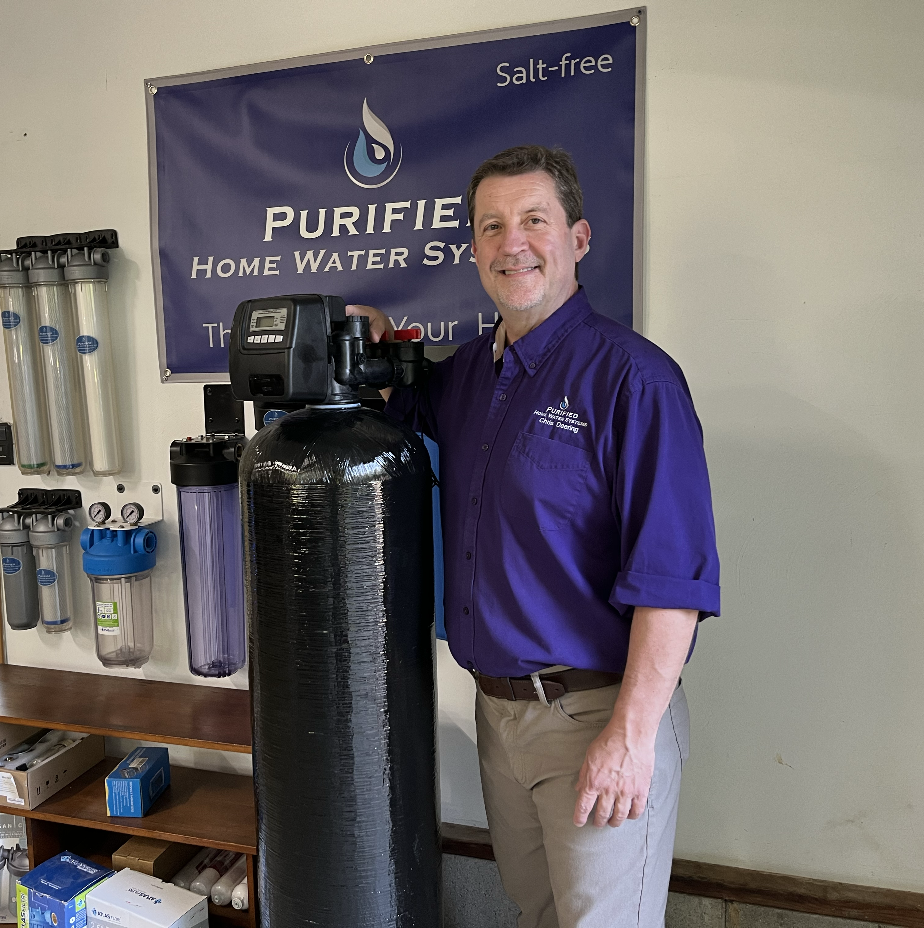 Owner, Chris, standing next to a purificaion sysem