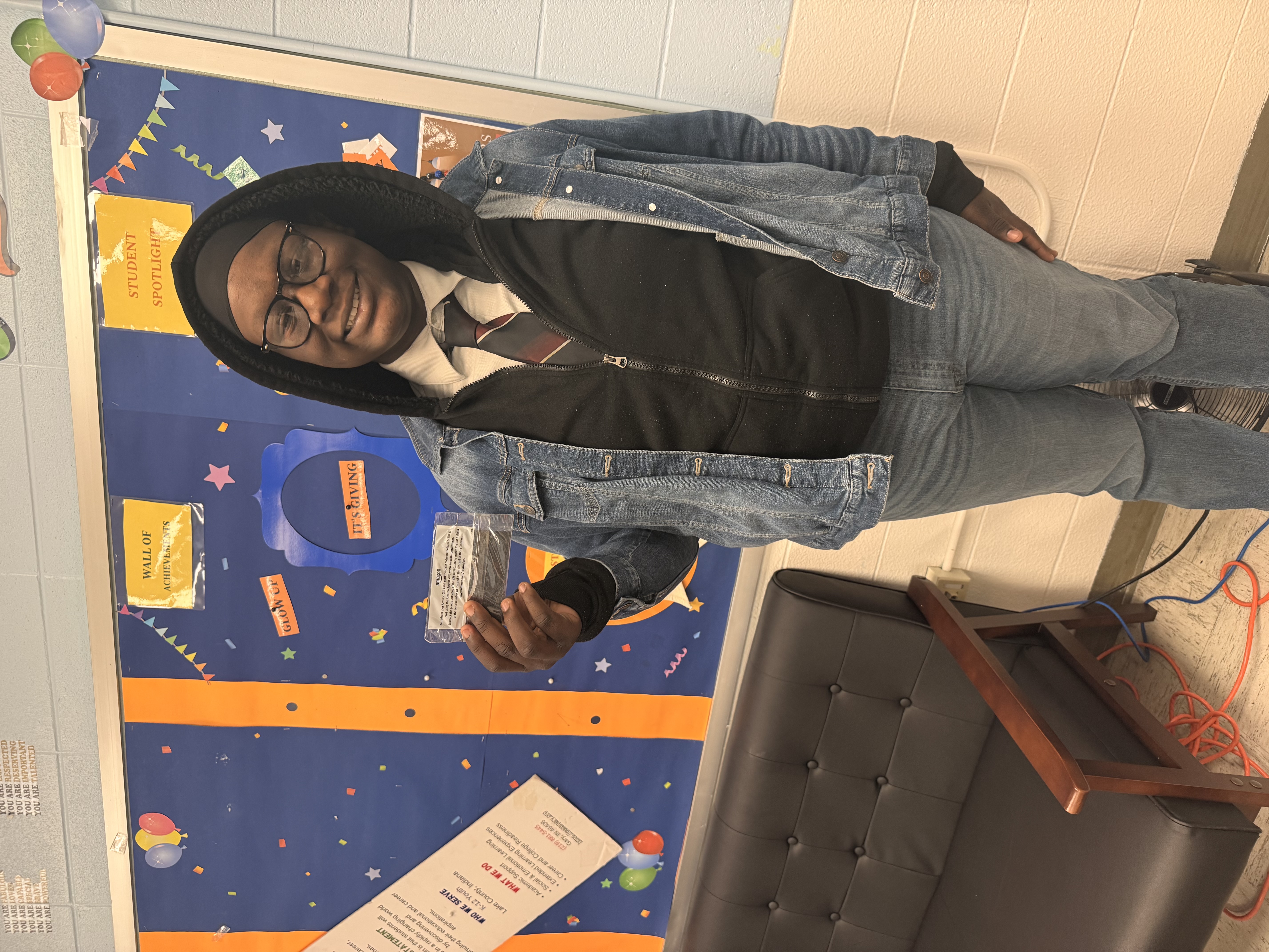 Antoine Gaines, a GAPS Student Ambassador, holding an appreciation gift card after supporting Career Day activities at school.