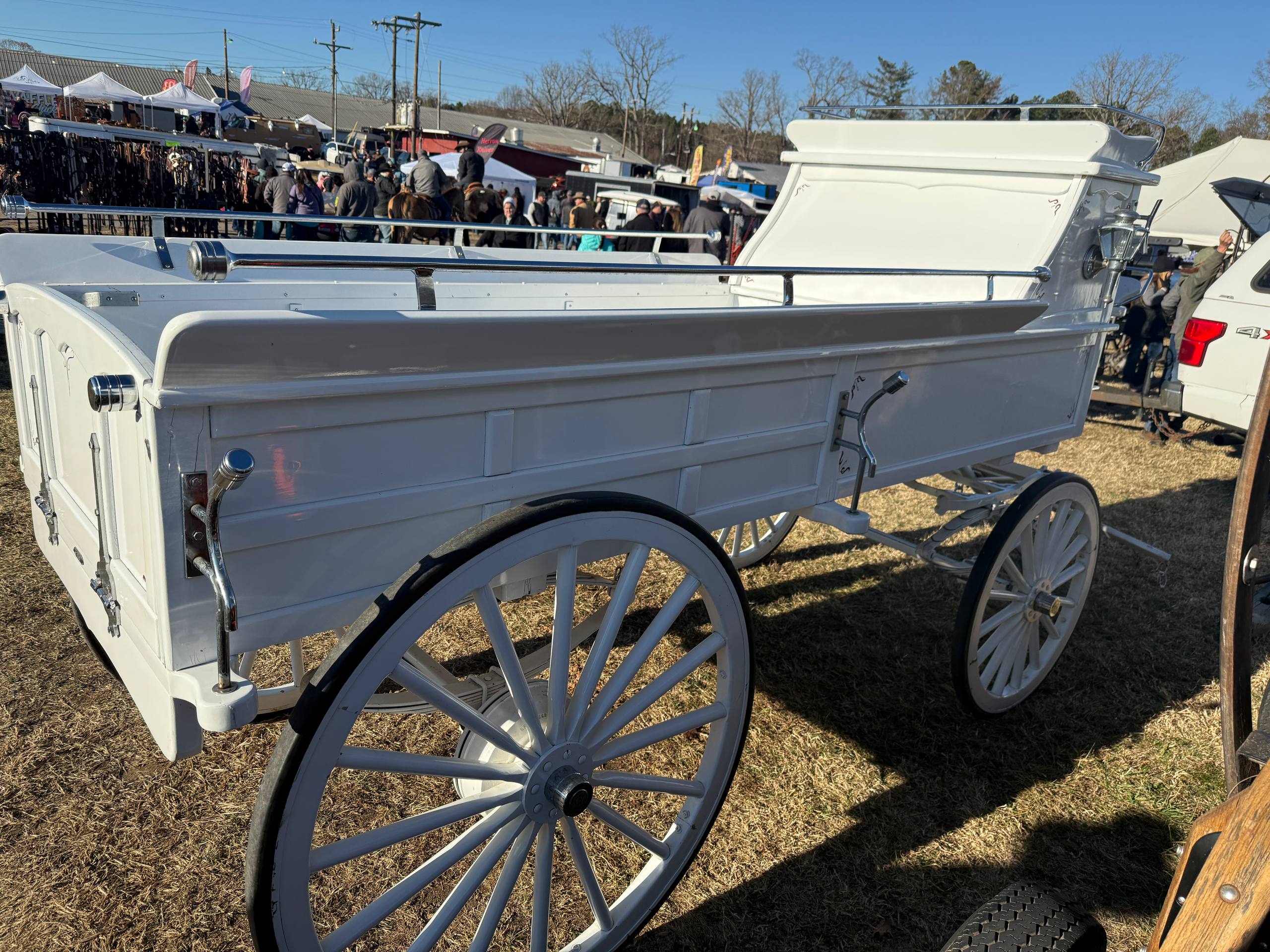 White hearse carriage on grass at a fair