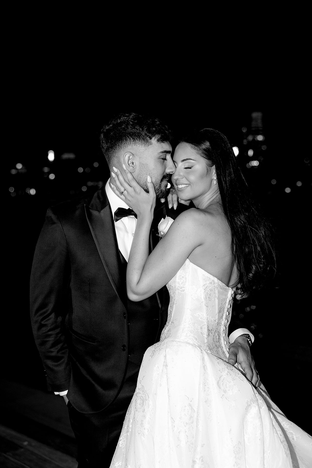 Black and white frame of a couple at night against the city lights