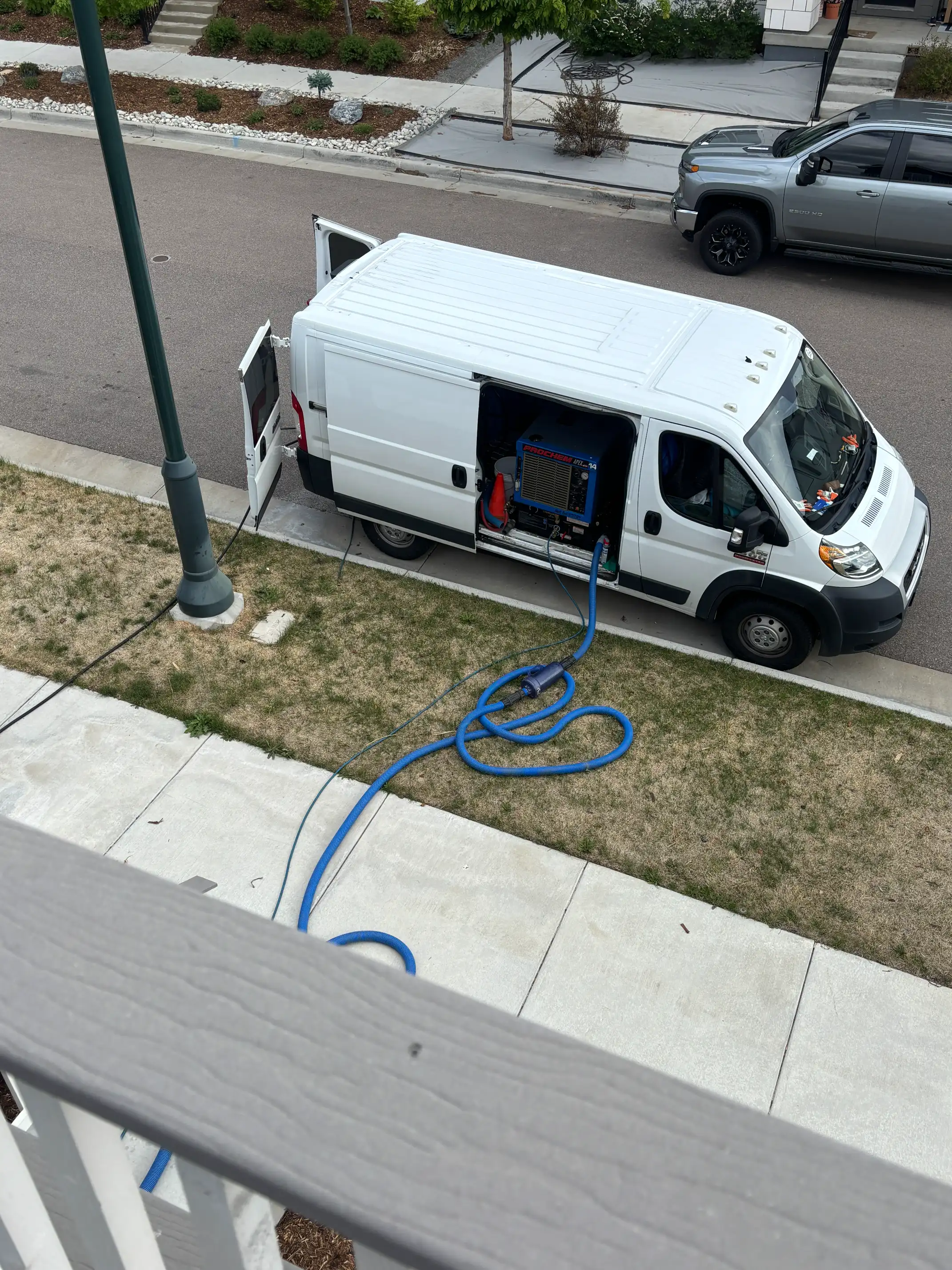 Colorado Choice van parked on a Wash Park side street, hose running to building entrance — shows the "inconvenience" the competitor refused