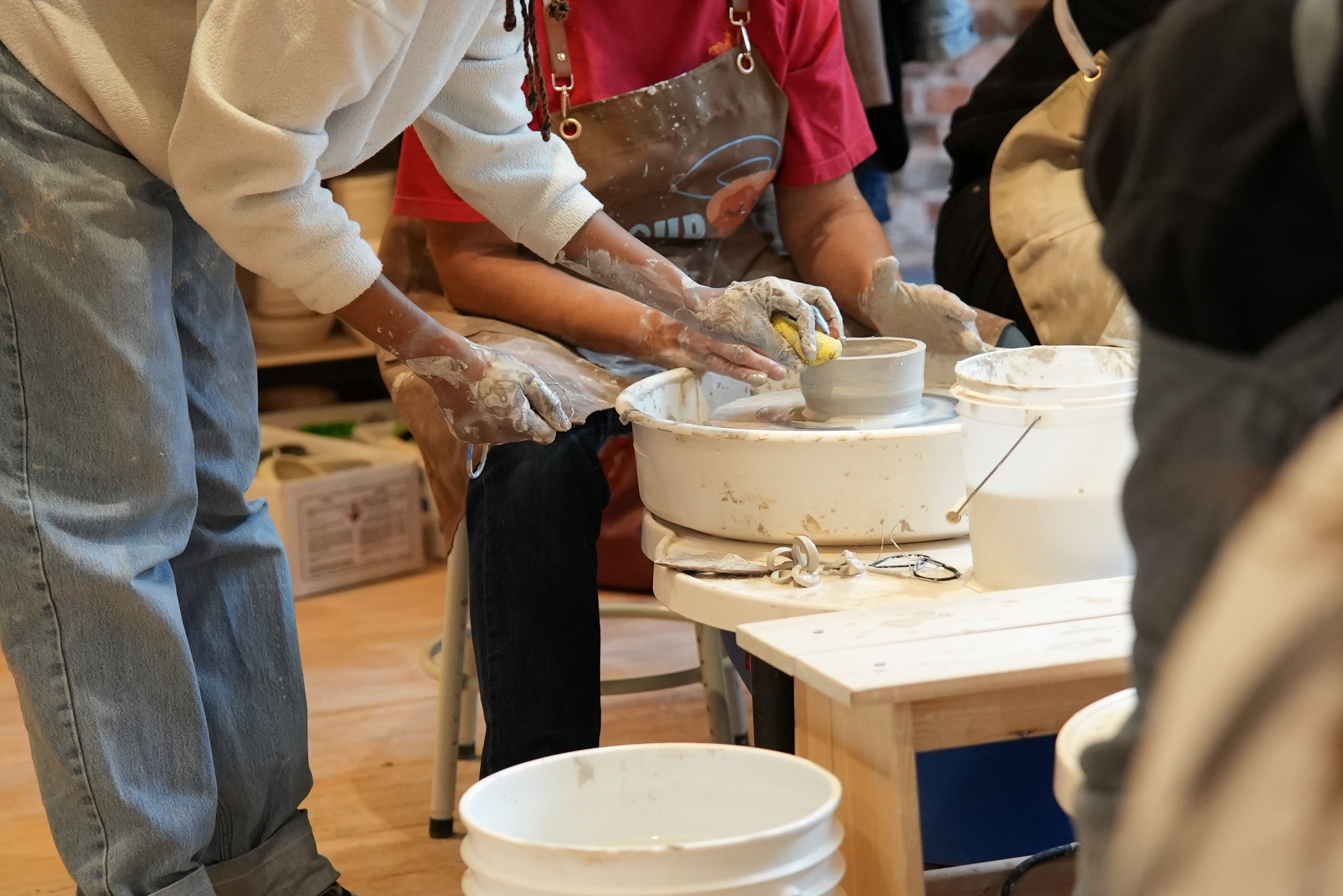 Student learning wheel throwing at Spin Pottery Studio